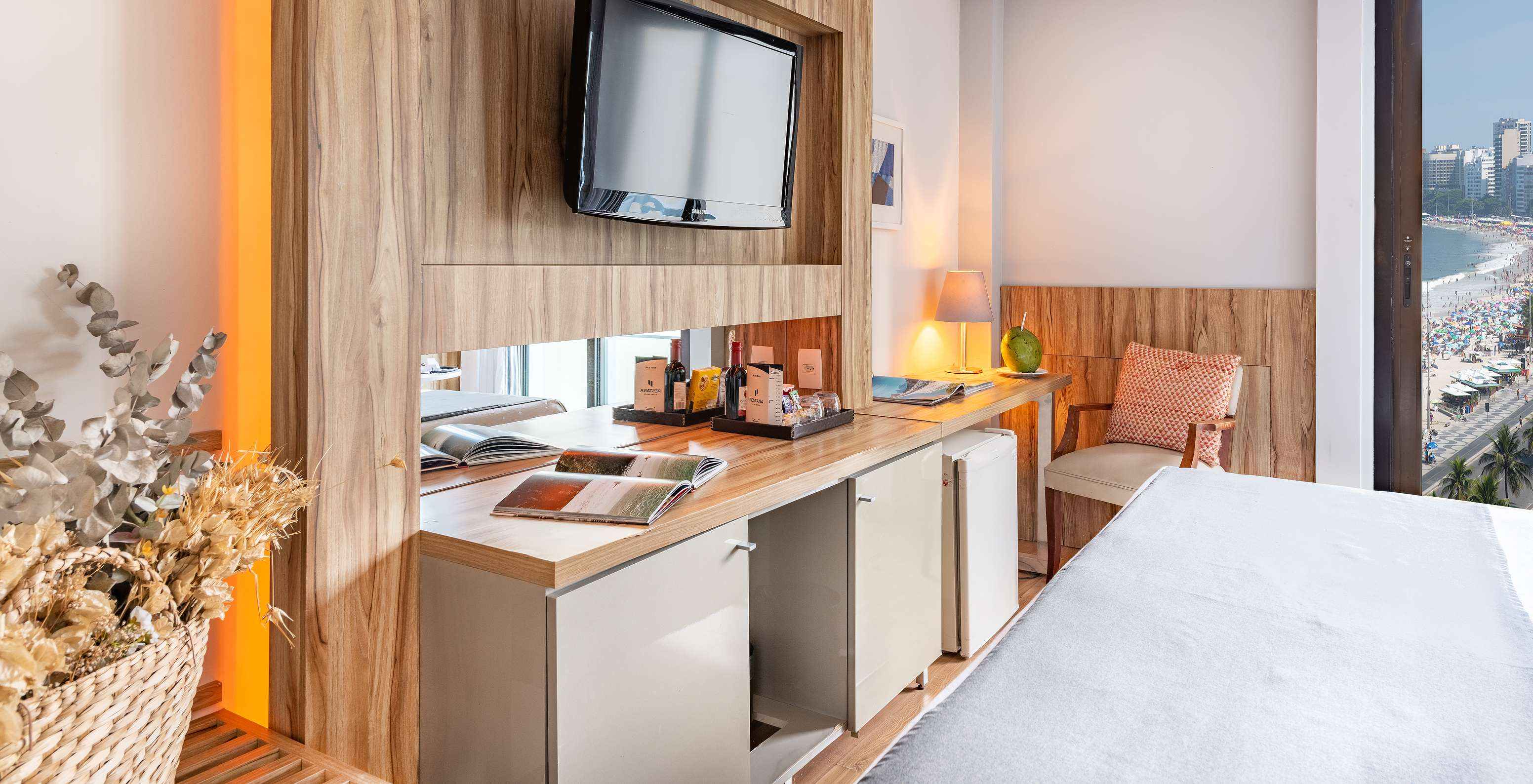 El Queen Vista Lateral al Mar del Pestana Rio Atlântica tiene una televisión enfrente de la cama y una silla acolchada