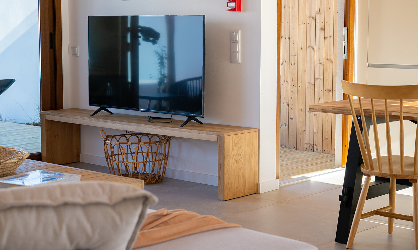 La Superior Green Villa de Pestana Comporta Village Residences tiene una sala moderna con TV y muebles de madera