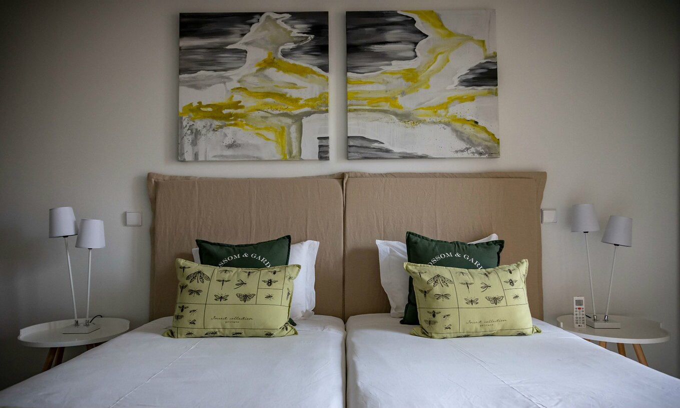 El Apartamento Eco Village Planta Baja del Pestana Tróia Eco Resort tiene dos camas juntas y cuadros en la pared