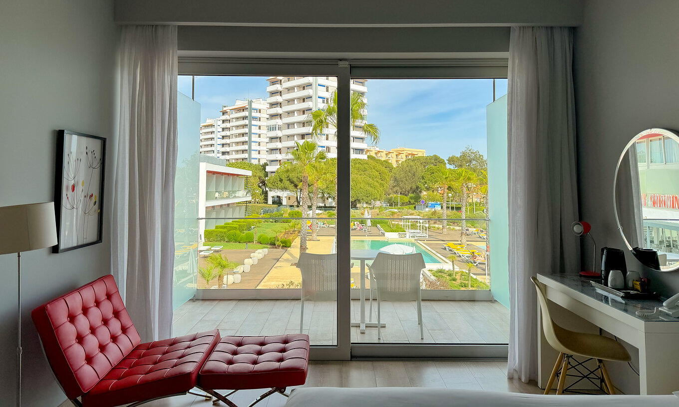El Superior Deluxe Vista Piscina del Pestana Alvor South Beach tiene terraza con mesa y dos sillas, y vista a la piscina
