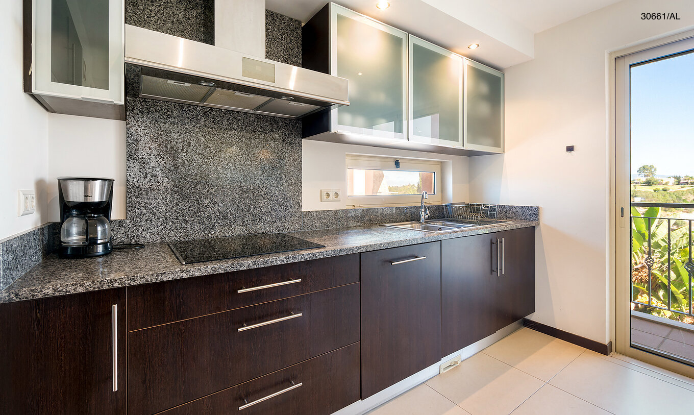 El apartamento Pestana Carvoeiro Golf T1 Superior tiene una cocina con gabinetes de madera oscura y encimera de granito