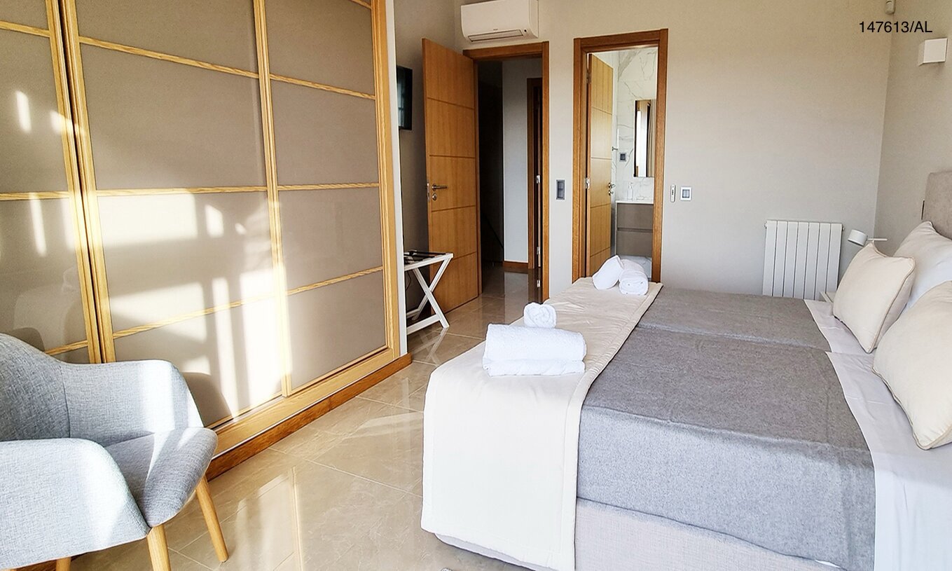 La villa Pestana Carvoeiro Golf V5 Superior tiene un dormitorio con dos camas individuales, sillón y mesita de noche