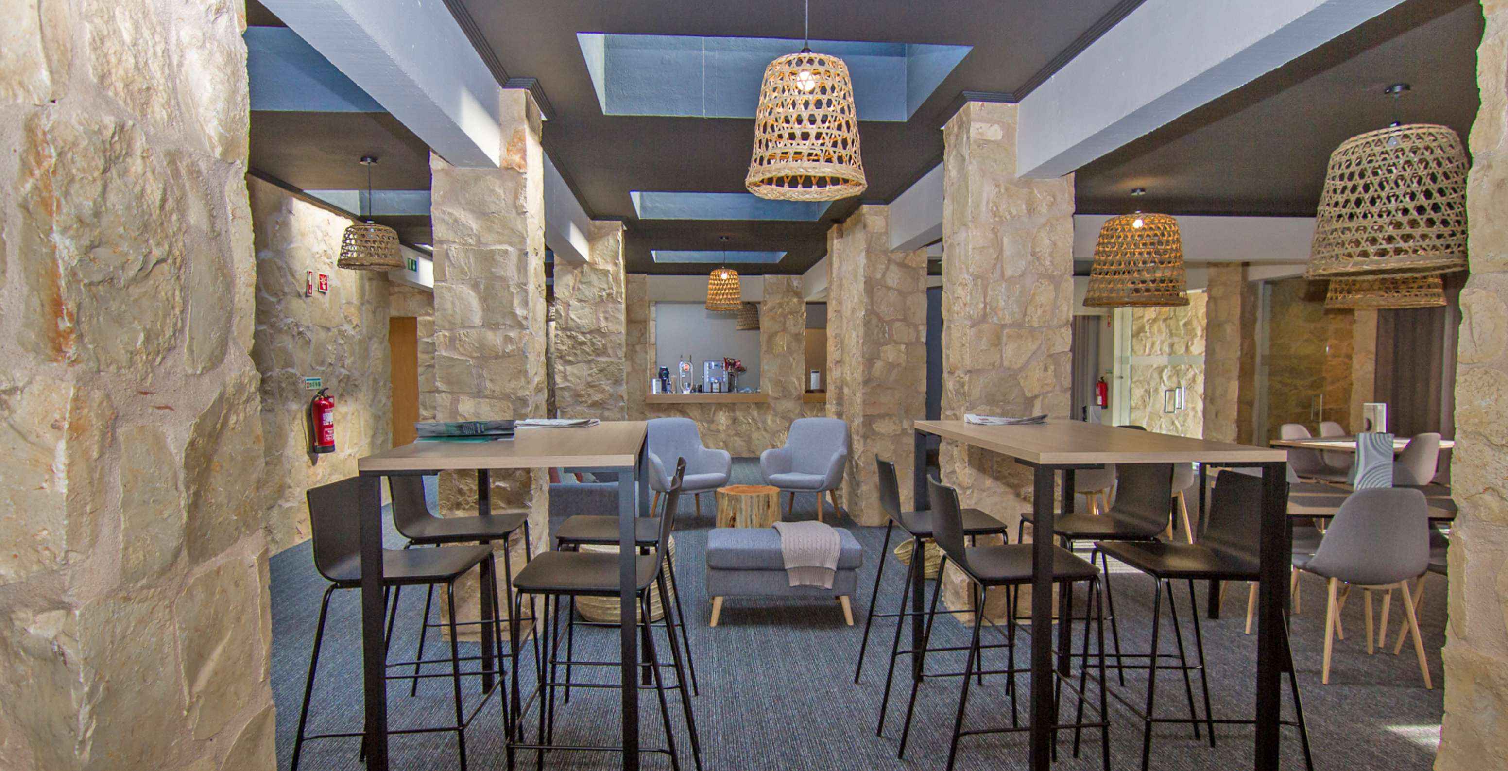 Restaurante de hotel con piscina, ubicado en un campo de golf, con dos mesas altas y mesas con sillas cómodas