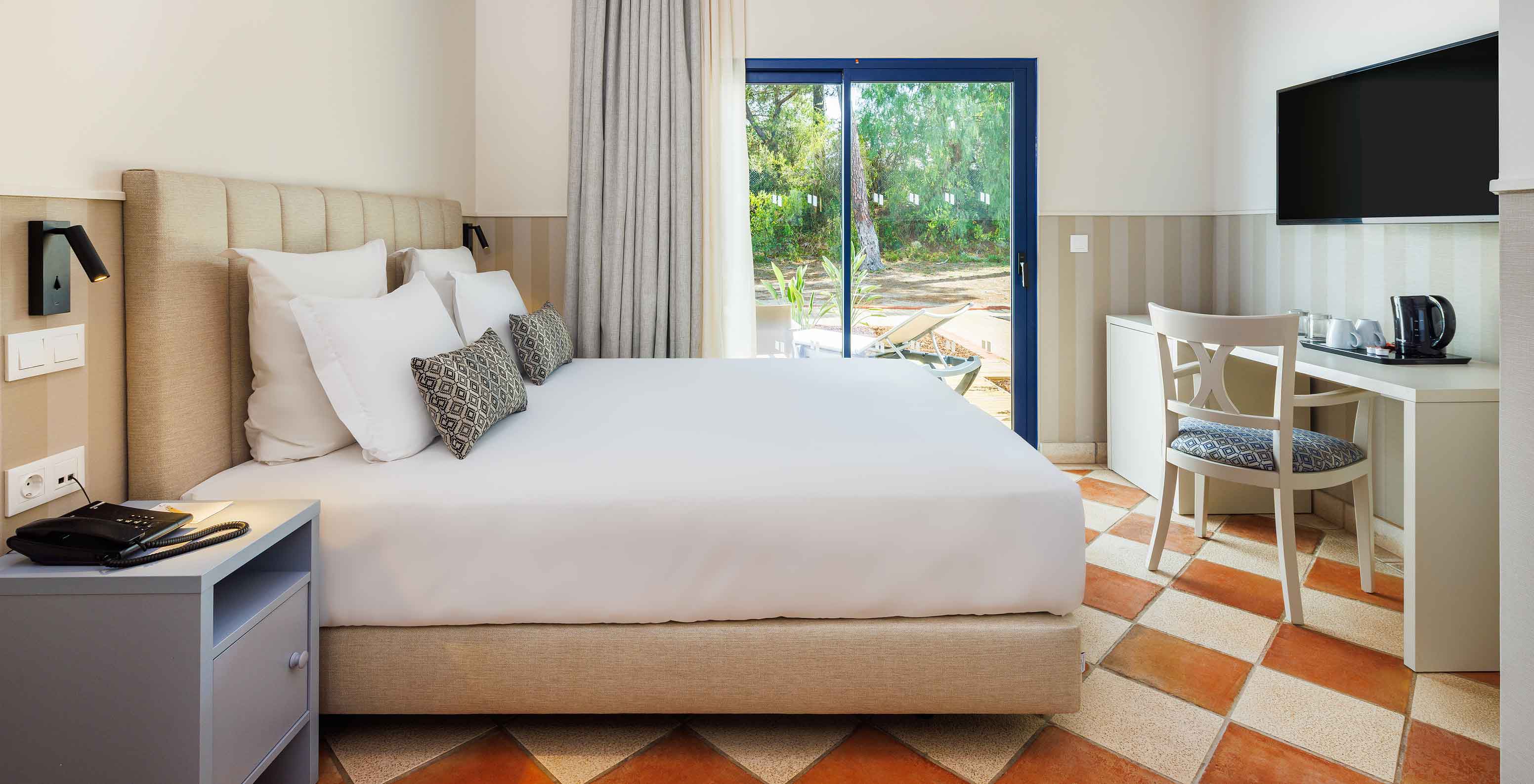 El Clásico Vista Jardín del Pestana Vila Sol - Vilamoura tiene una cama de casal, un escritorio con una silla y ventana con balcón