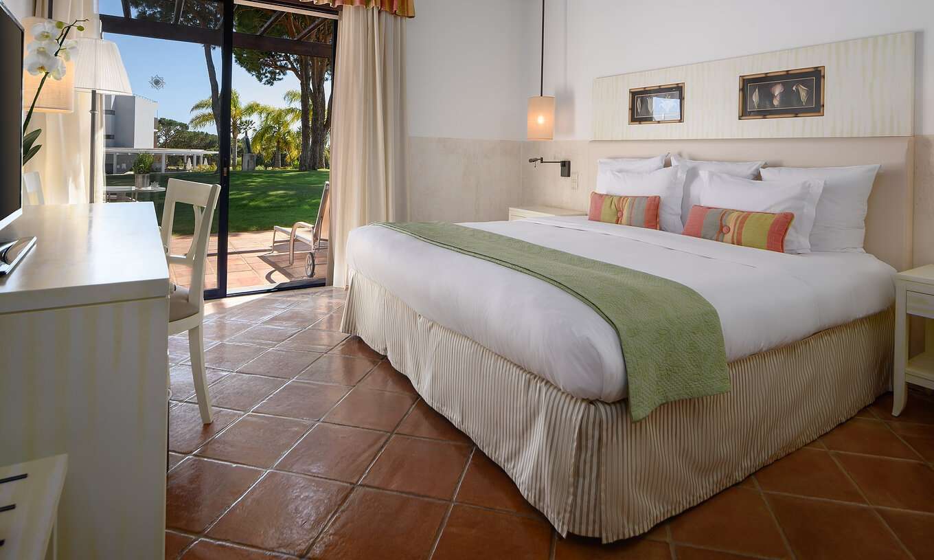 La Suite Vista Jardín Resort del Pestana Vila Sol - Vilamoura tiene una cama de casal, un escritorio y un balcón con tumbona