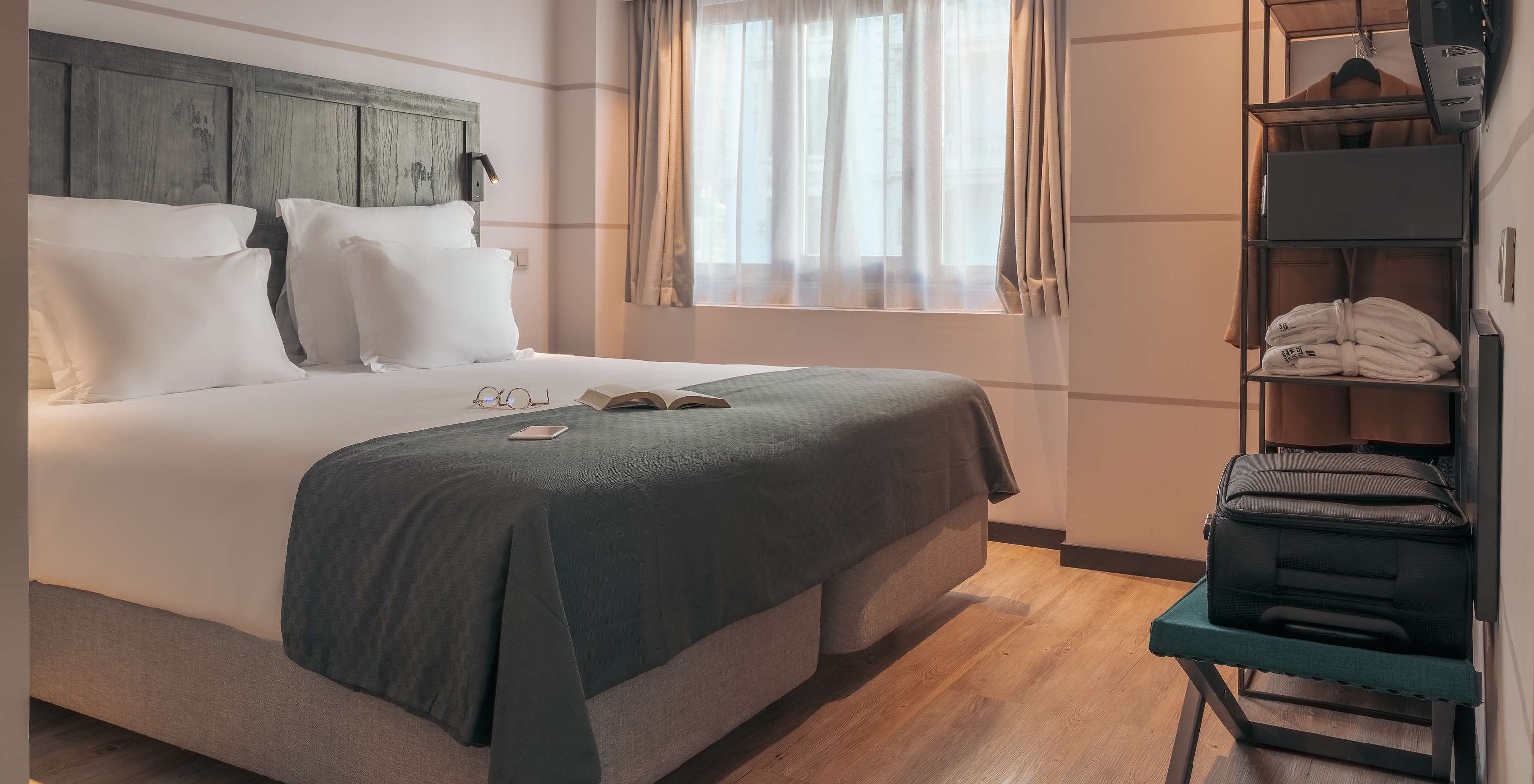 El Double Deluxe Studio del Pestana Lisboa Vintage tiene una cama matrimonial con una manta gris y un armario con un abrigo