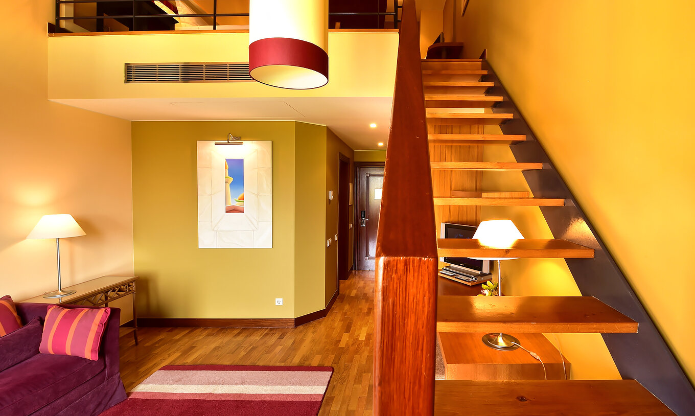 La Suite Mezzanine Jacuzzi del Pestana Sintra Golf tiene un sofá, escaleras a la mezzanine, cuadro y lámpara