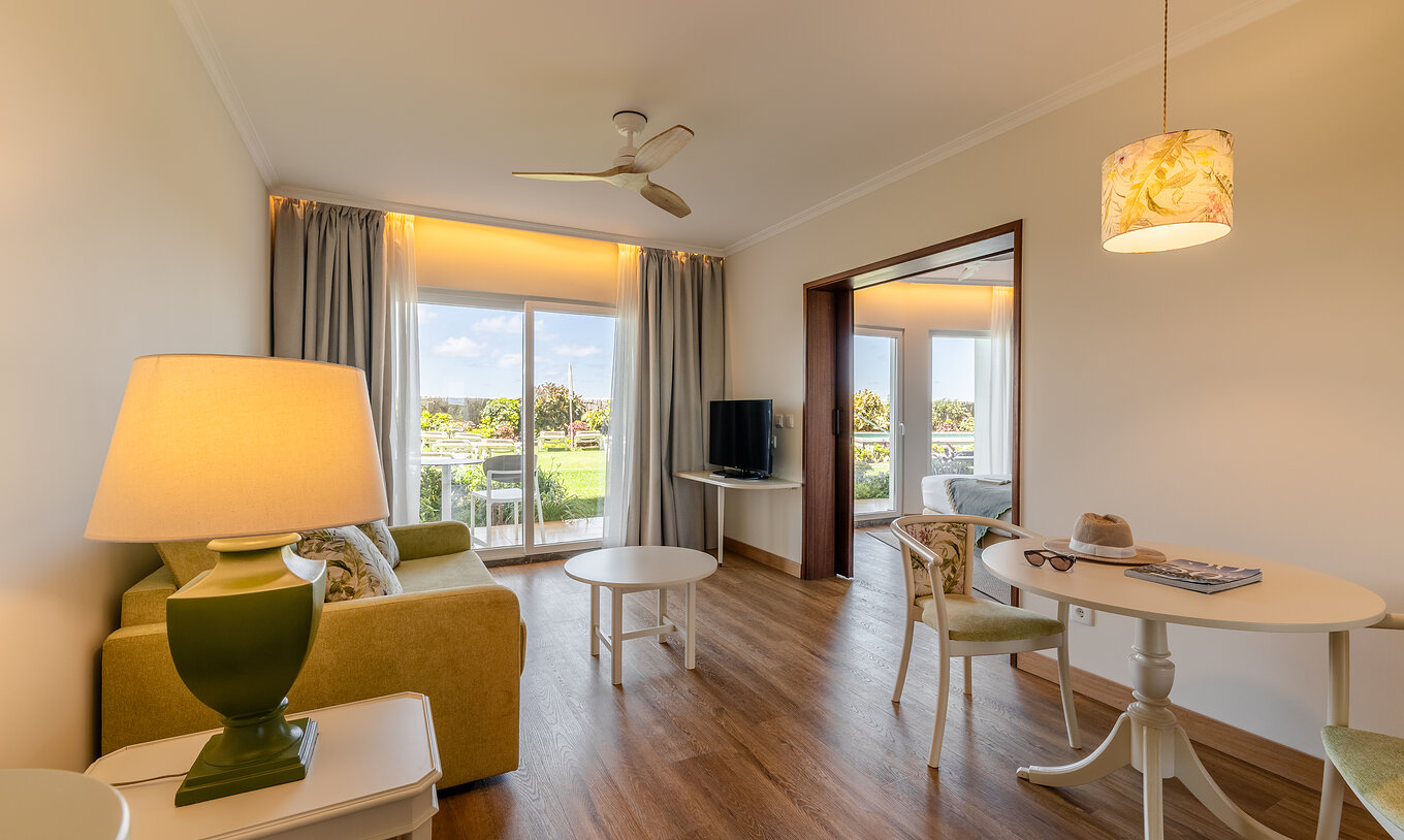 La Junior Suite Sea View del Pestana Ocean Bay All Inclusive tiene una sala luminosa, con sofá, mesa de centro y de comedor