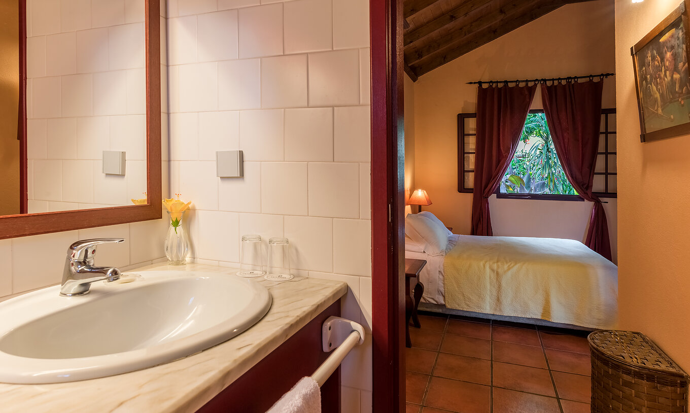 Las Villas del Pestana Quinta do Arco tienen baño con lavabo y la puerta abierta al cuarto con cama de casal
