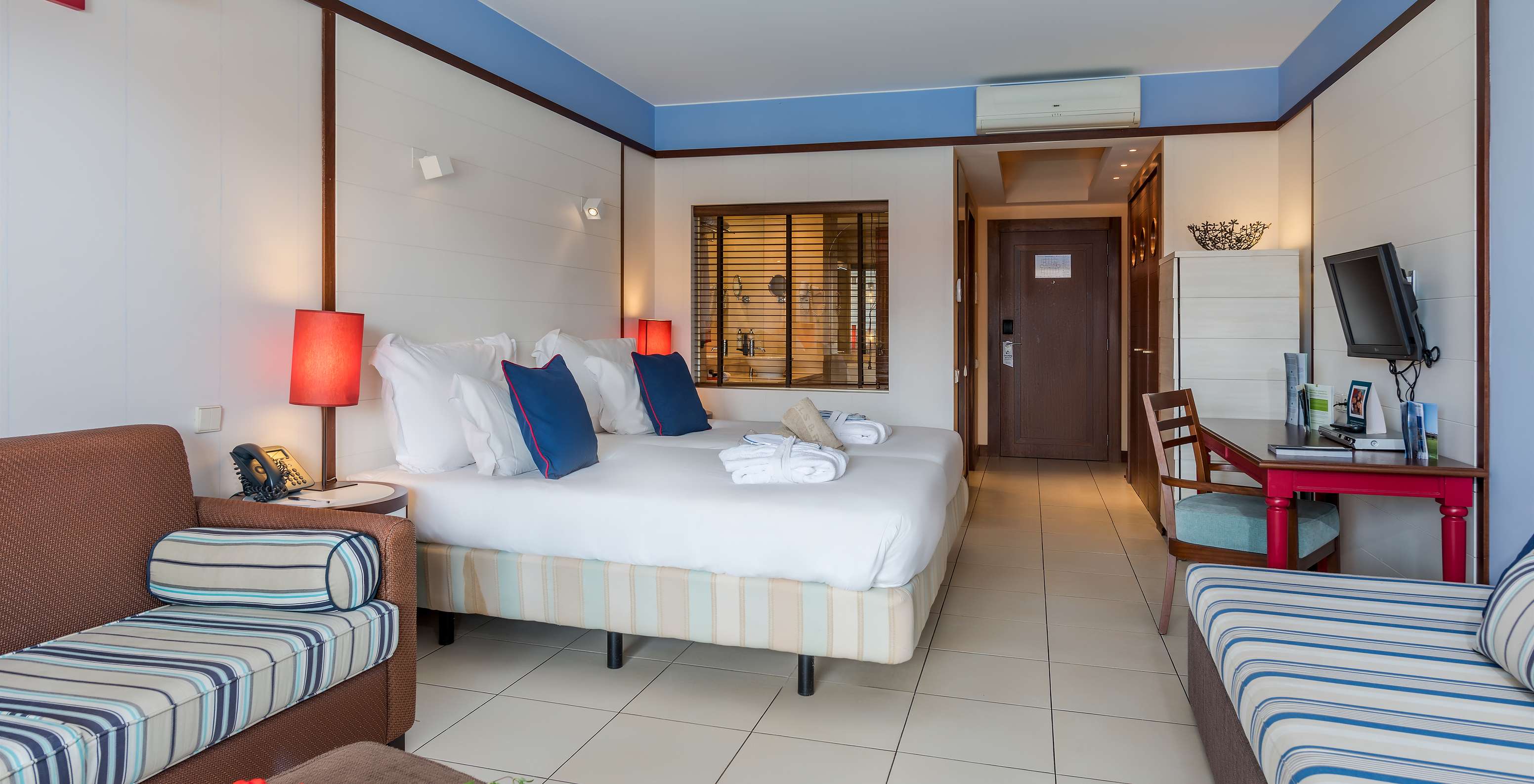 El Doble Familiar del Pestana Porto Santo All Inclusive tiene dos camas, dos sofás, un escritorio y una televisión