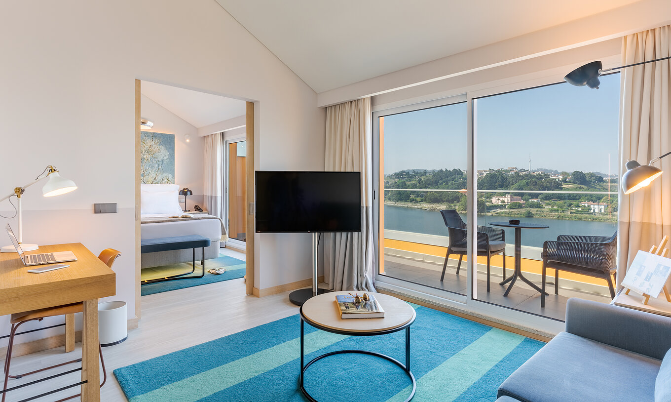 La Suite del Pestana Douro Riverside cuenta con televisión, mesa y terraza con mesas y sillas con vista al río Douro