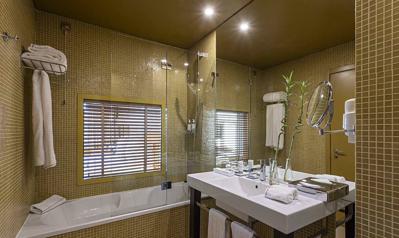 El Executive Superior tiene un baño con bañera y una ventana al dormitorio