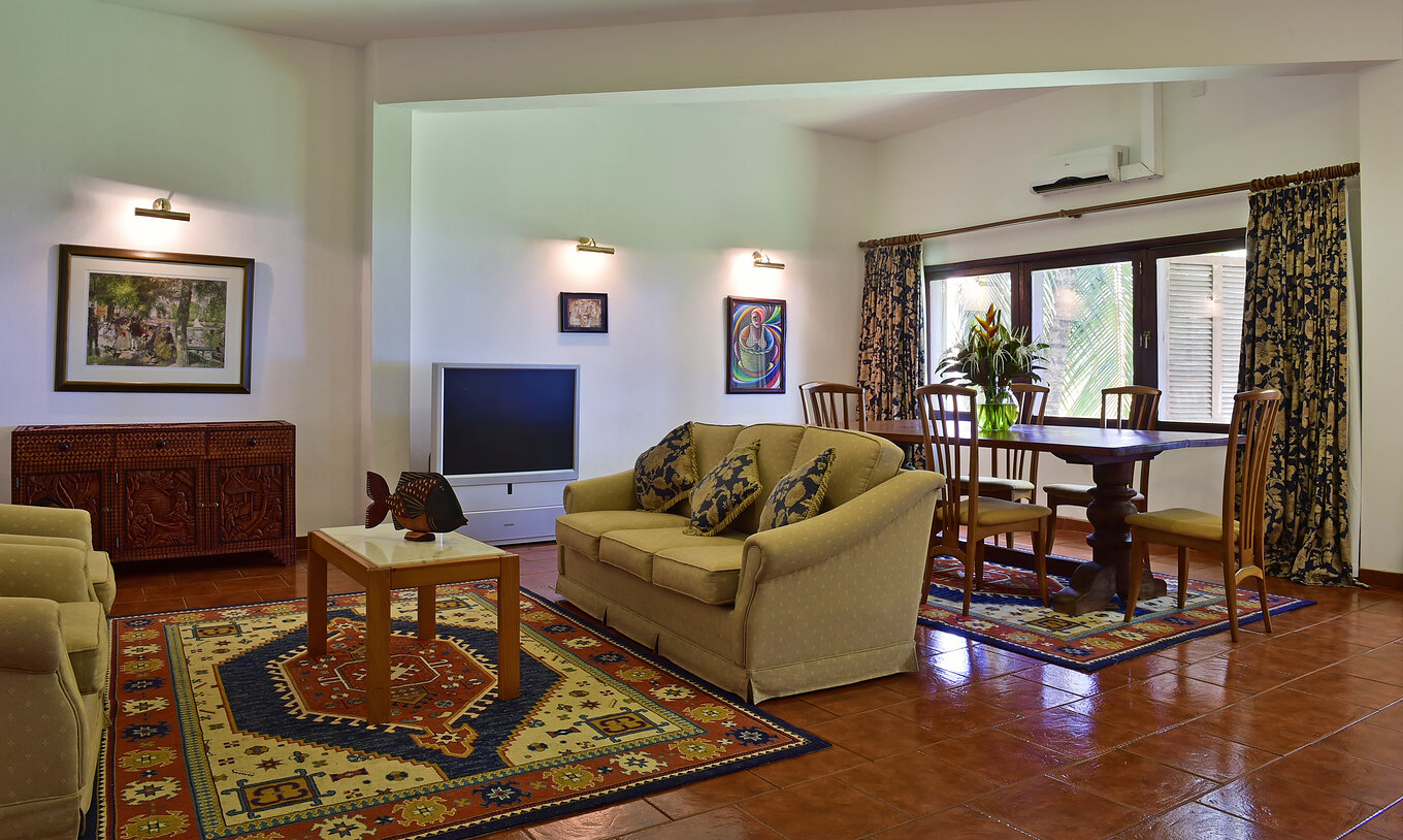 La Suite Presidencial del Pestana Miramar São Tomé tiene una sala de estar con tres sofás, una mesa de comedor y televisor