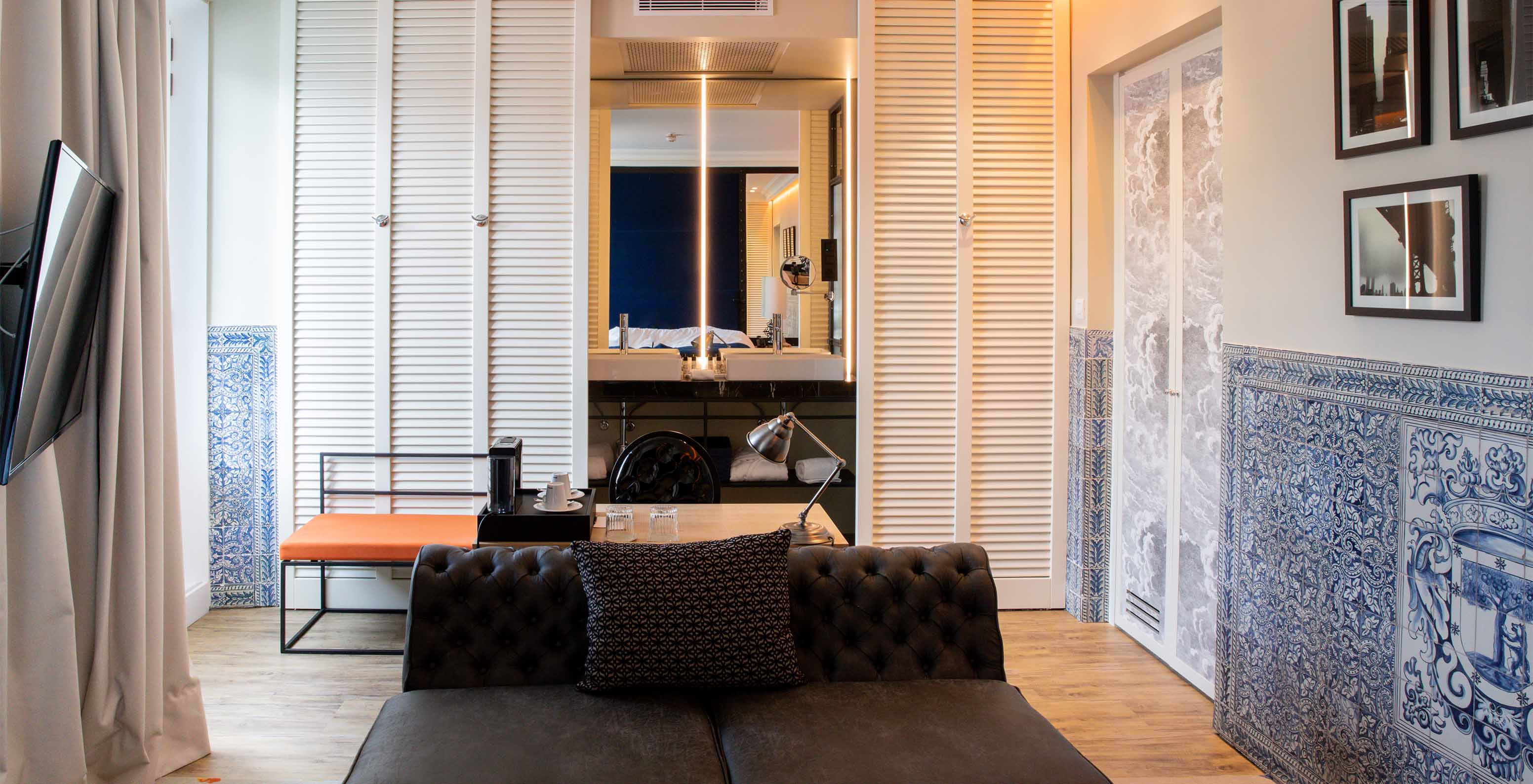 El Deluxe Plaza Mayor del Pestana Collection Plaza Mayor tiene una sala con sofá, televisión y azulejos azules y blancos