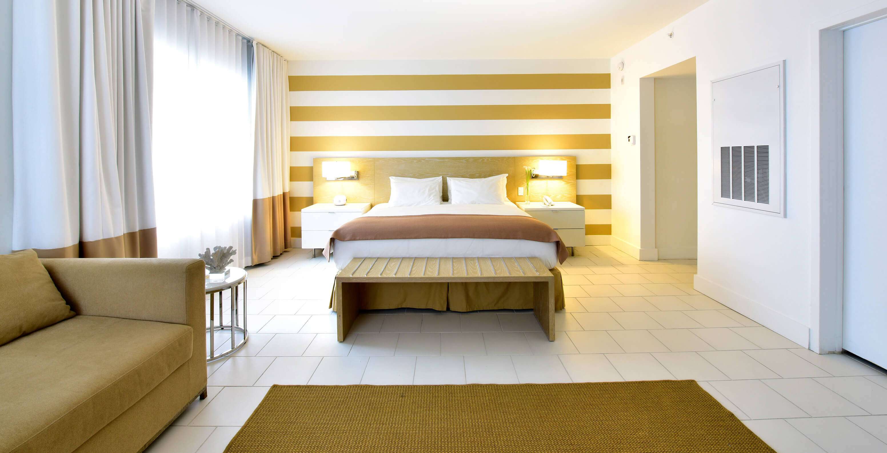 El Deluxe con sofá cama del Pestana Miami South Beach cuenta con cama matrimonial, mesa de noche y lámpara