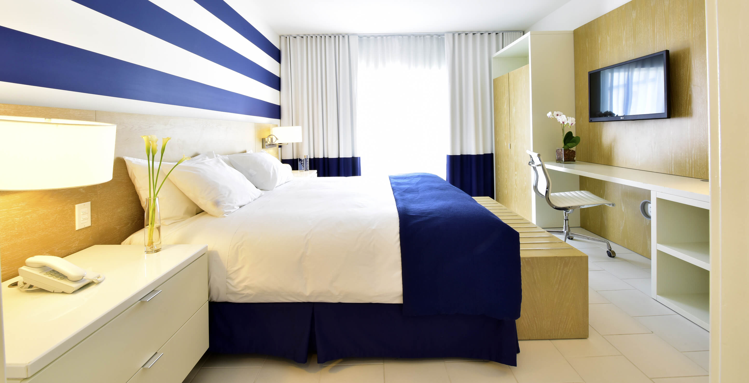 La Suite King con Balcón del Pestana Miami es moderna con cama grande y decoración azul y blanca.