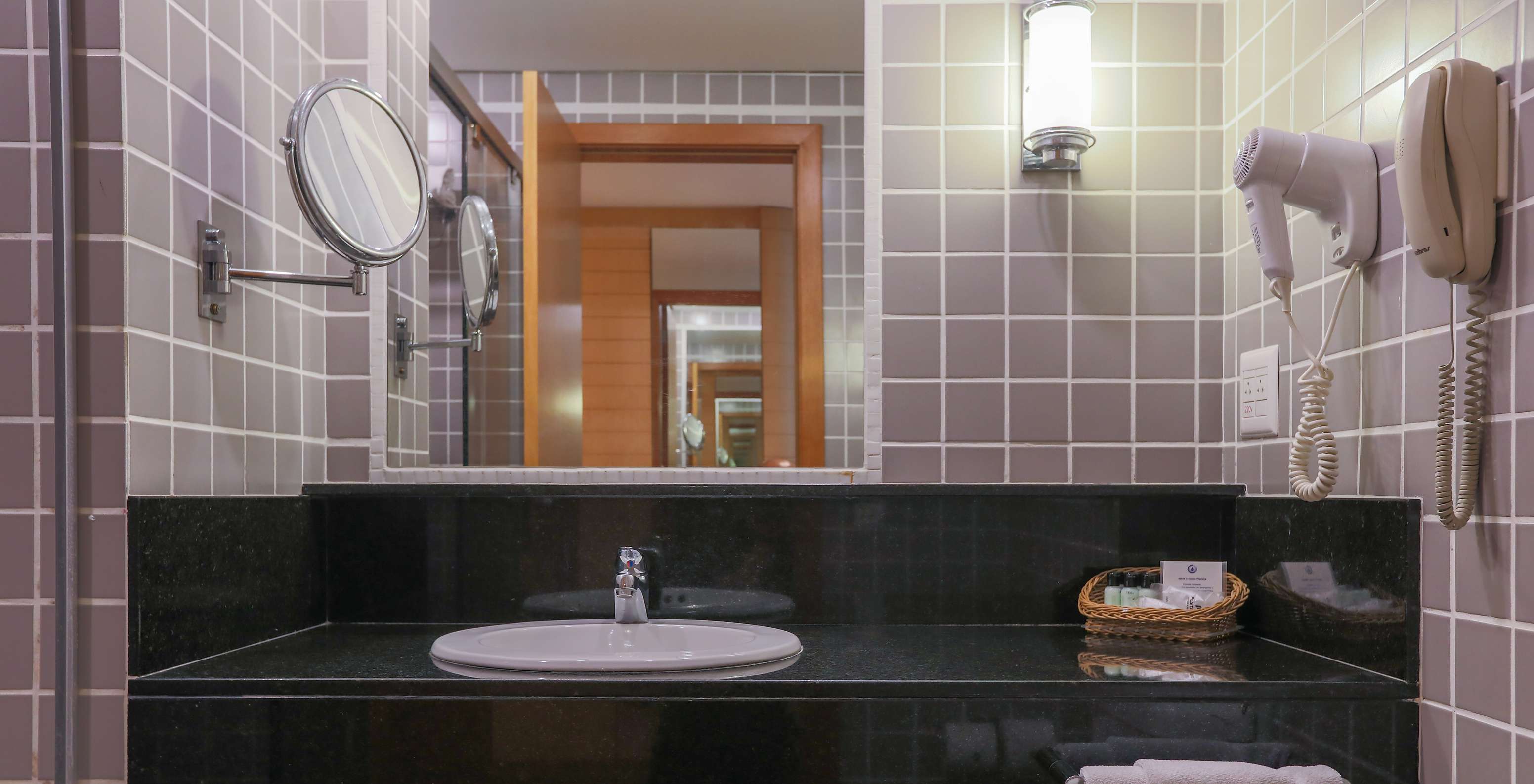 Le Queen Standard du Pestana Curitiba a une salle de bain avec carreaux gris et meuble noir avec lavabo