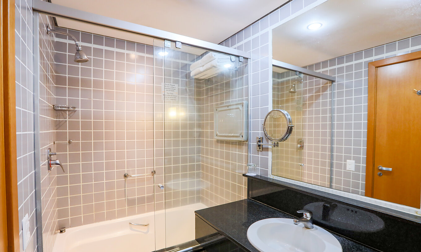 Le Quarto Familial du Pestana Curitiba a une salle de bain avec baignoire et un meuble noir avec lavabo