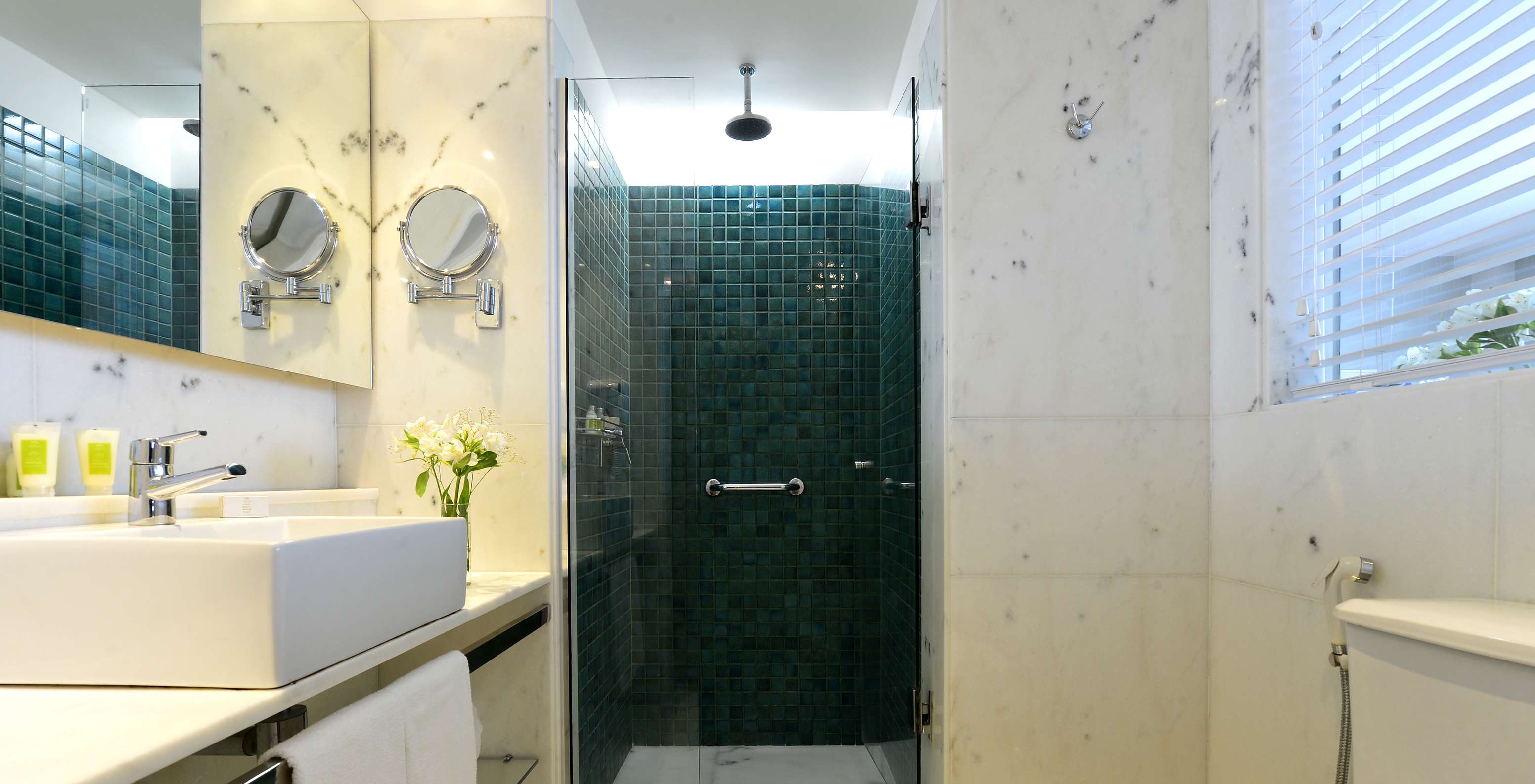 Le Twin Vue Latérale Sur la Mer du Pestana Rio Atlântica a une salle de bain avec douche, toilettes, lavabo et miroir