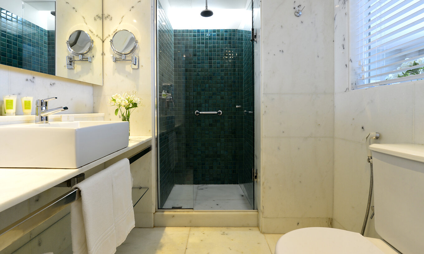 Le Twin Vue Latérale Sur la Mer du Pestana Rio Atlântica a une salle de bain avec douche, toilettes, lavabo et miroir