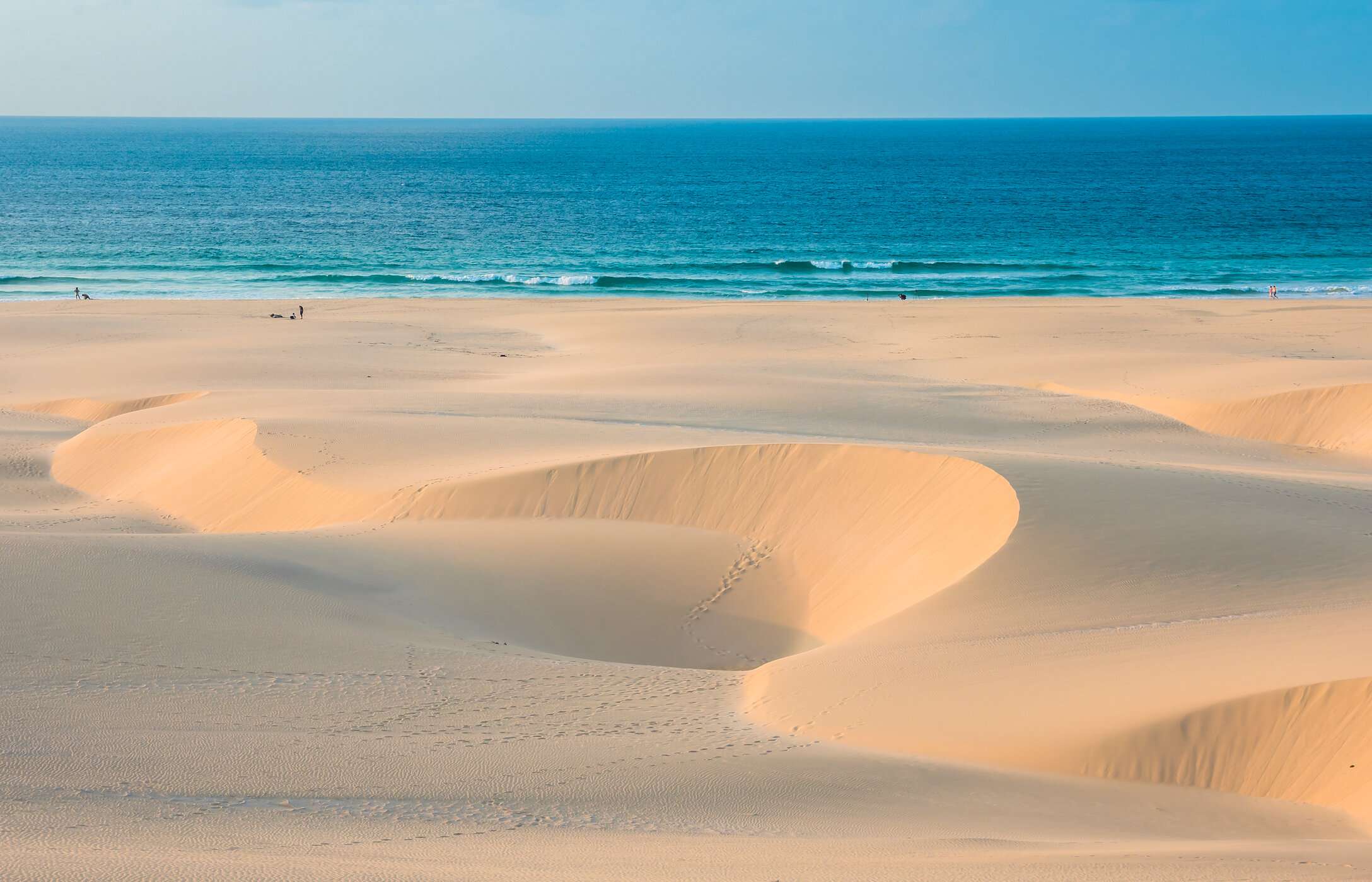 Vue panoramique de la plage de Chaves avec des dunes de sable sculptées par le vent contrastant avec la mer bleu turquoise
