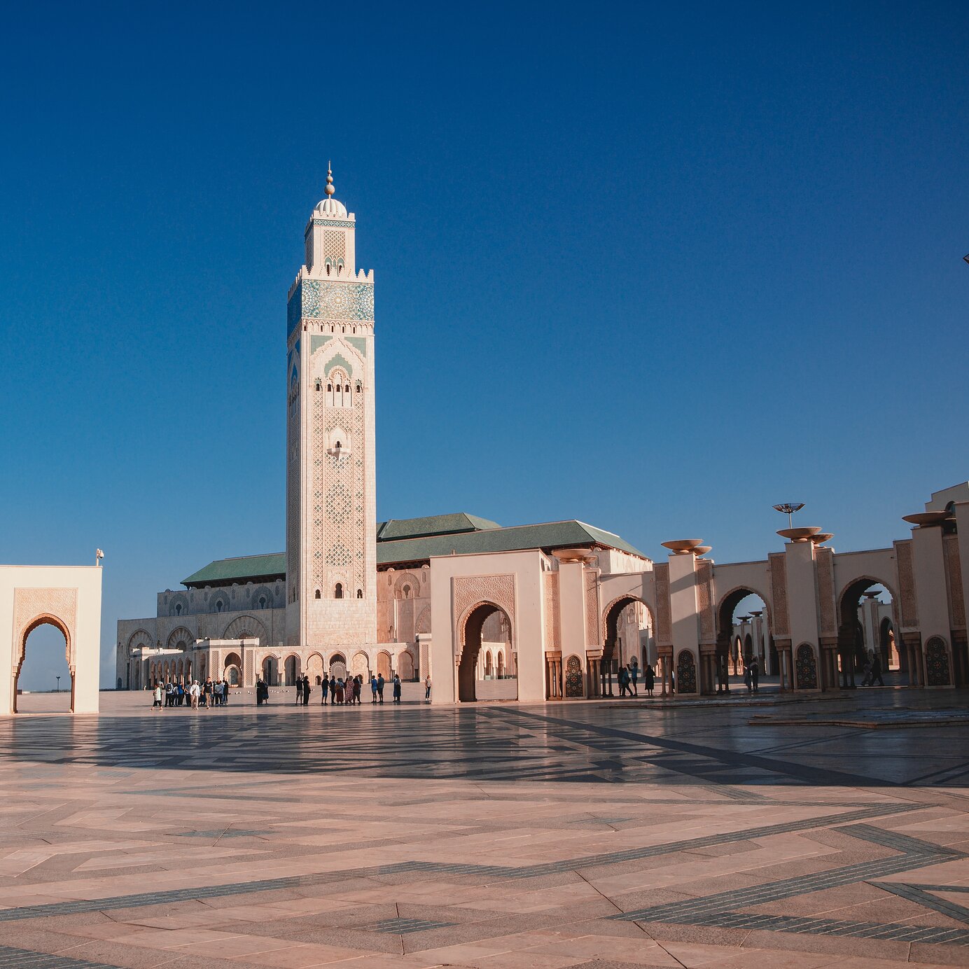 Séjournez dans un hôtel Pestana et explorez la mosquée Hassan II à Casablanca, Maroc, avec une grande place devant.
