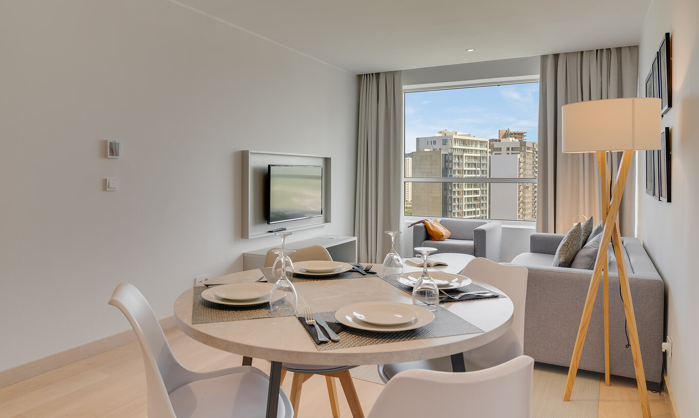 La suite familiale premium du Pestana Tanger City Center a un salon avec télévision, canapé et table de repas