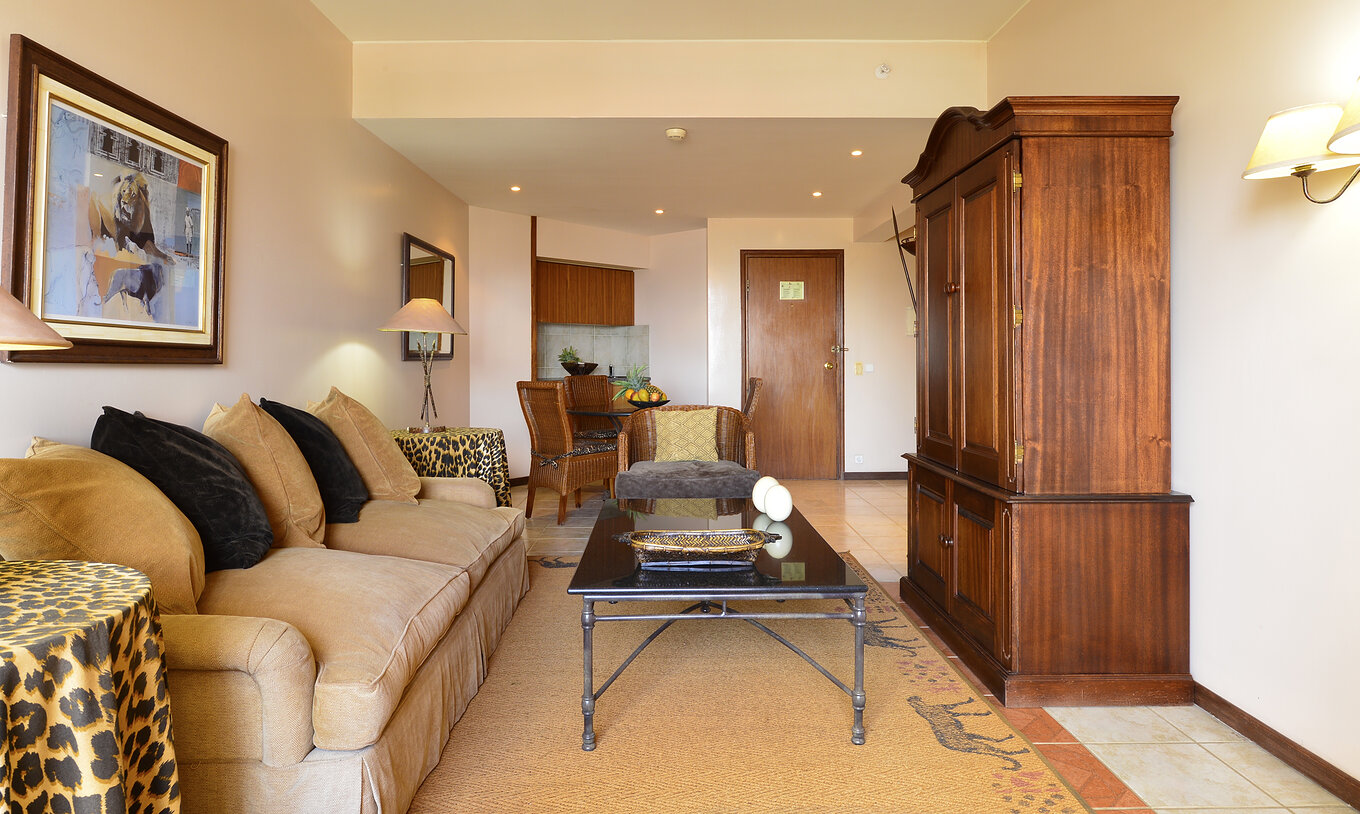 La Suite Luxe du Pestana Rovuma a un salon avec un canapé blanc beige et deux tables avec nappes léopard