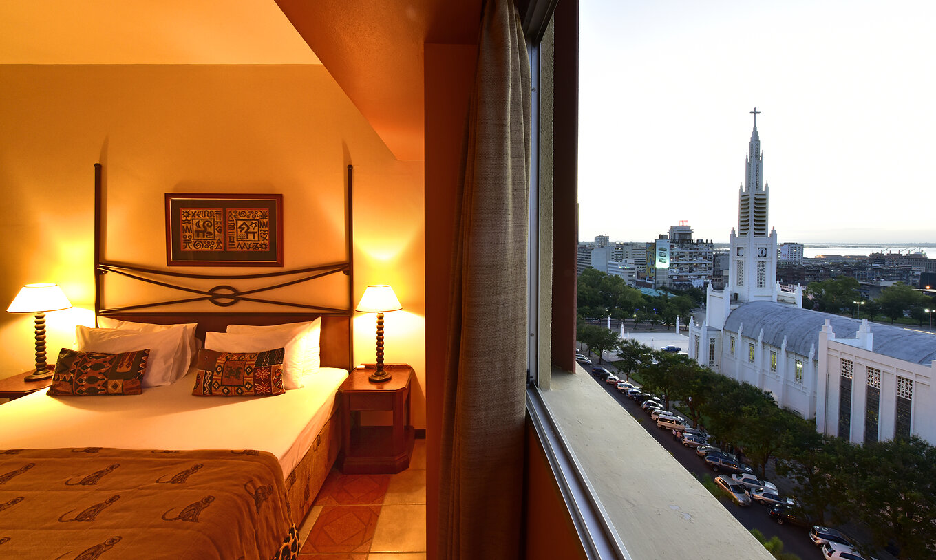 La Suite Exécutive du Pestana Rovuma a à côté du lit une fenêtre avec vue sur la ville de Maputo, y compris la cathédrale