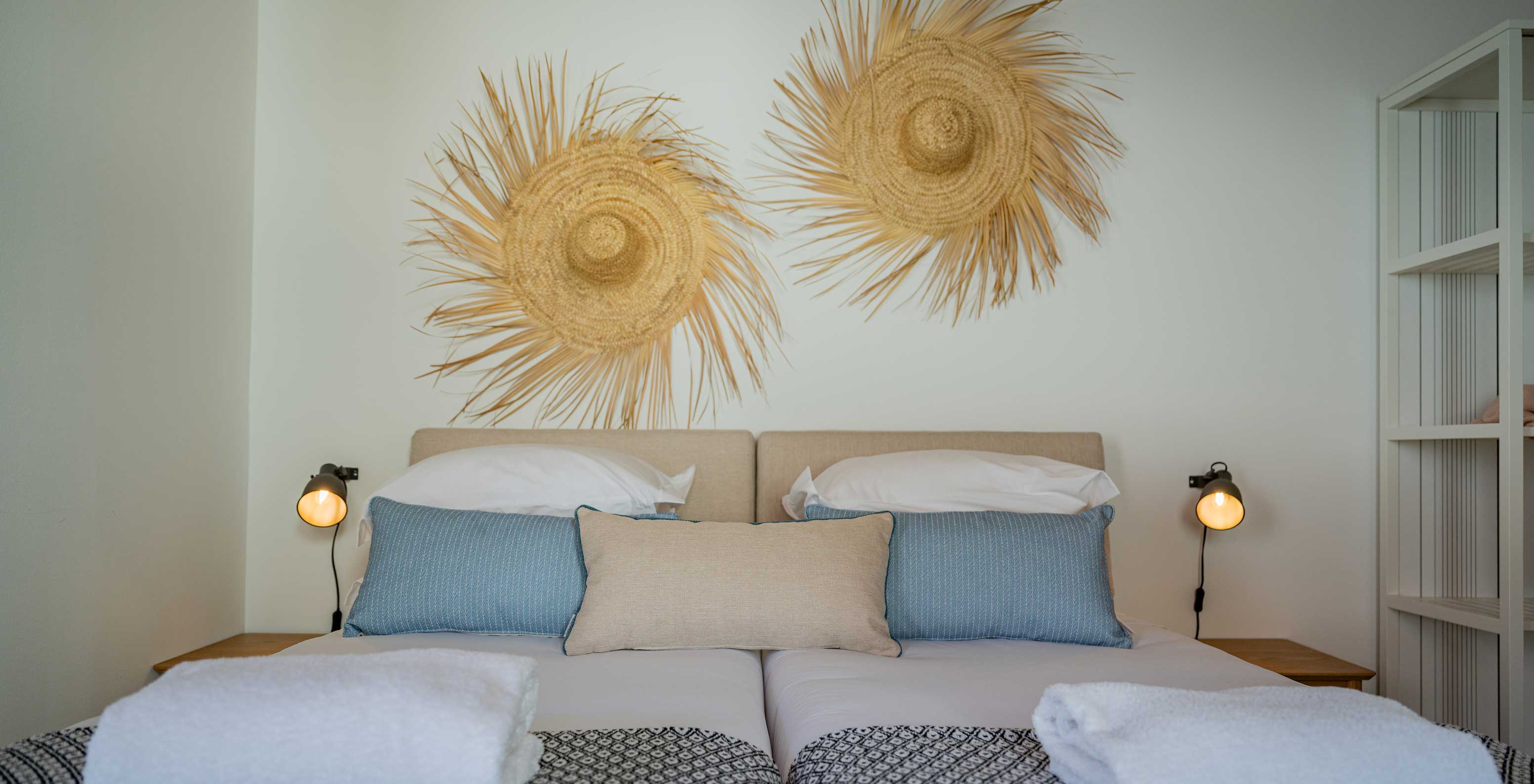 La Standard Villa du Pestana Comporta Village Residences dispose d'un lit double avec décoration en paille sur le mur