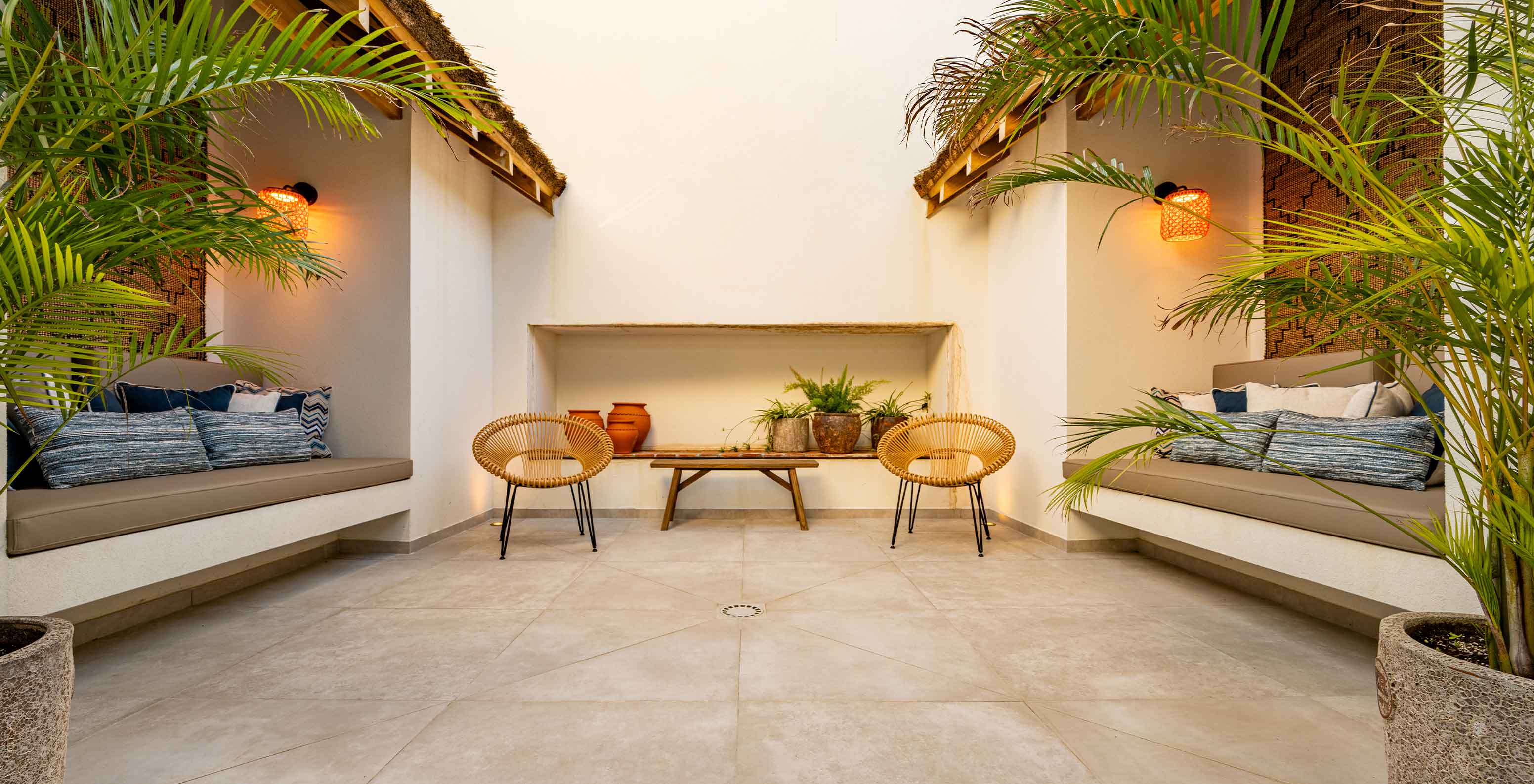 Espace de détente extérieur avec bancs, chaises et végétation, au Pestana Comporta Village Residences