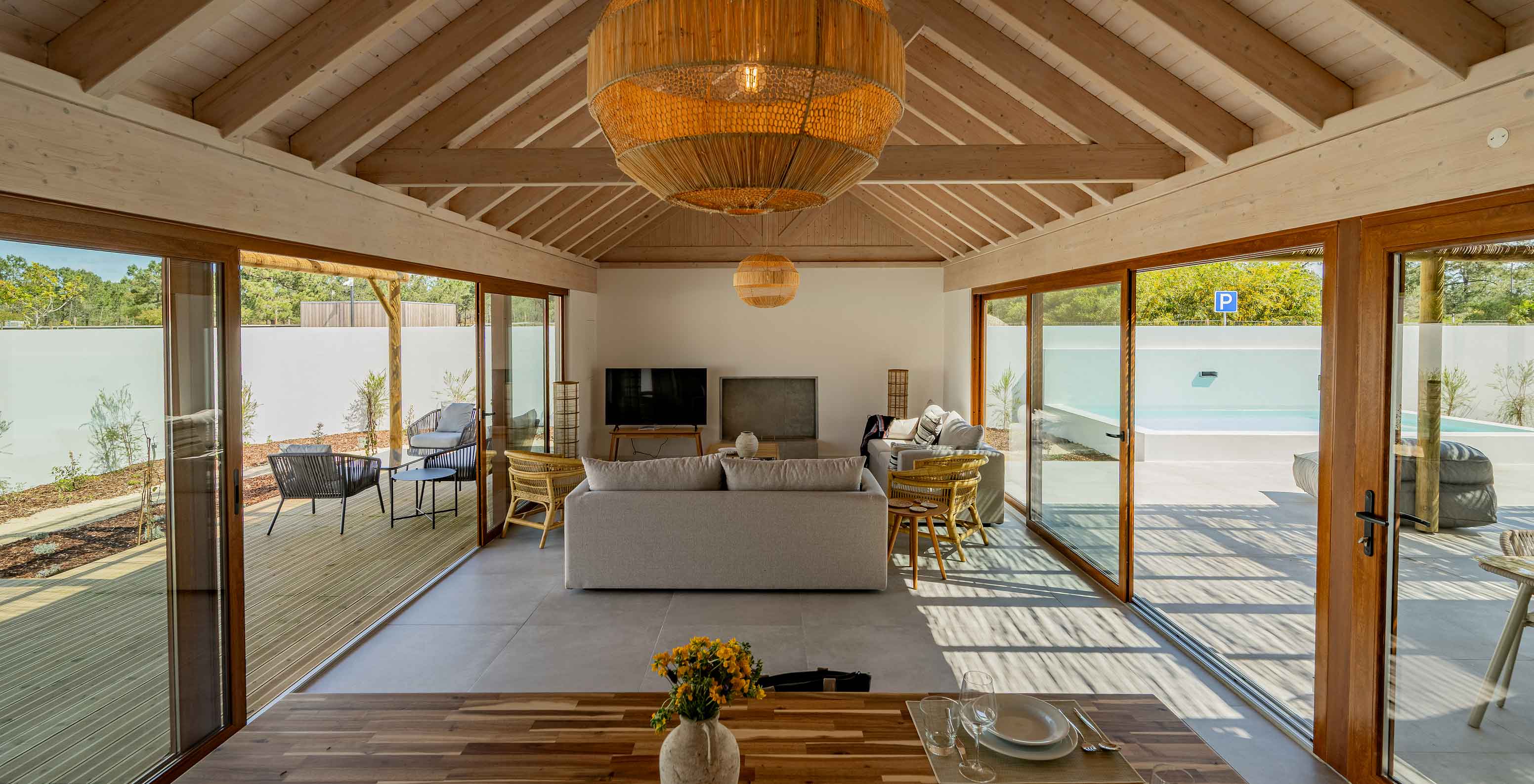 La Premium Green Villa du Pestana Comporta Village Residences dispose d'un salon moderne avec grandes fenêtres et table