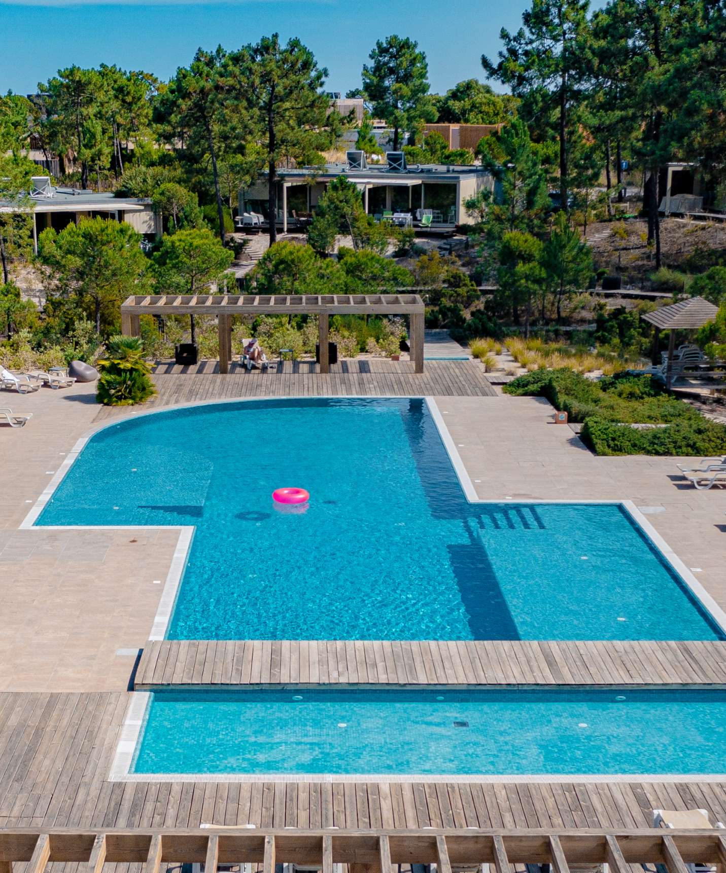 Piscine extérieure du resort à Tróia, près de Comporta, avec des chaises longues autour et de la nature environnante