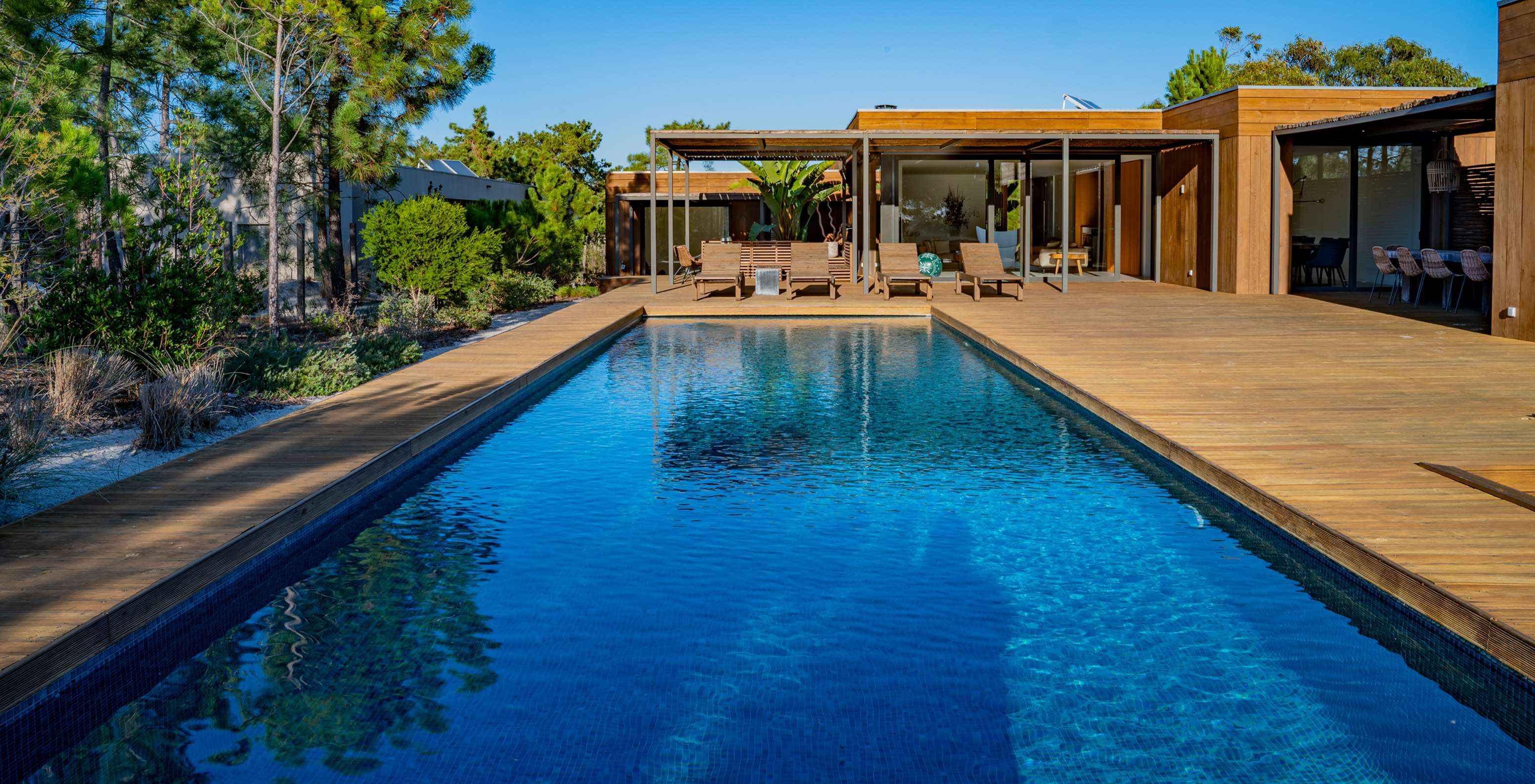 Les Exclusive Villas avec piscine privée du Pestana Tróia Eco Resort ont une grande piscine avec plusieurs chaises longues