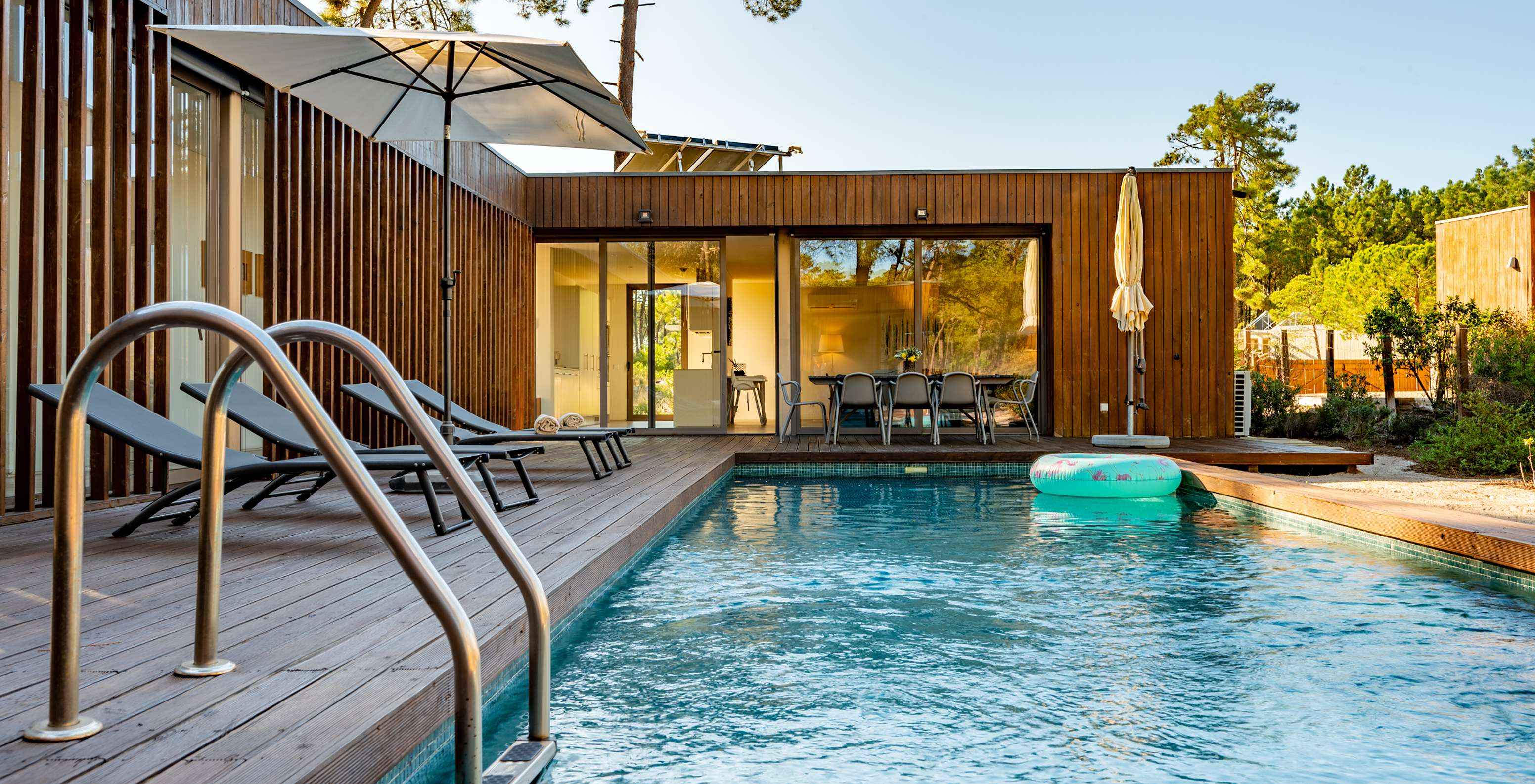 Le Deluxe 4 Bedroom Villas avec piscine privée du Pestana Tróia Eco Resort a des chaises longues dans la zone de la piscine