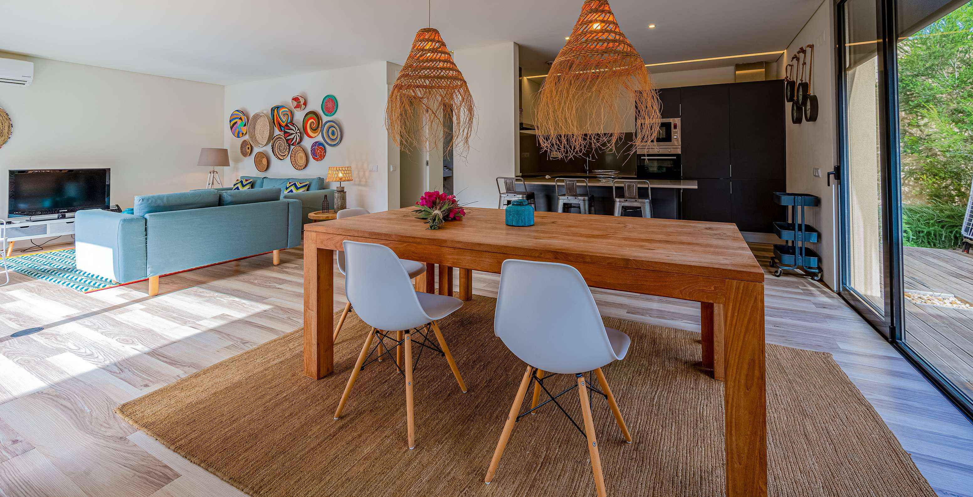 Les Pine Villas du Pestana Tróia Eco Resort ont une salle avec une table en bois, lampes et une cuisine
