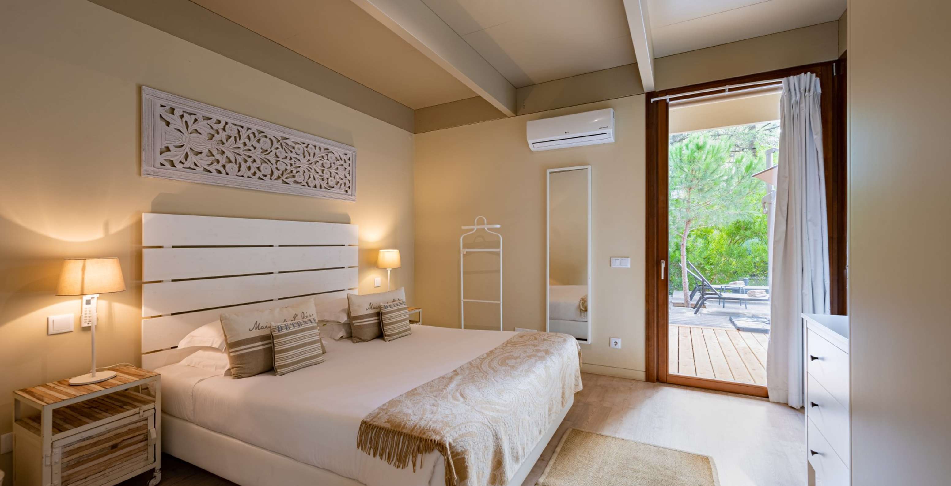 Les Sand Villas avec piscine privée du Pestana Tróia Eco Resort ont un lit double avec un couvre-lit et un miroir au mur