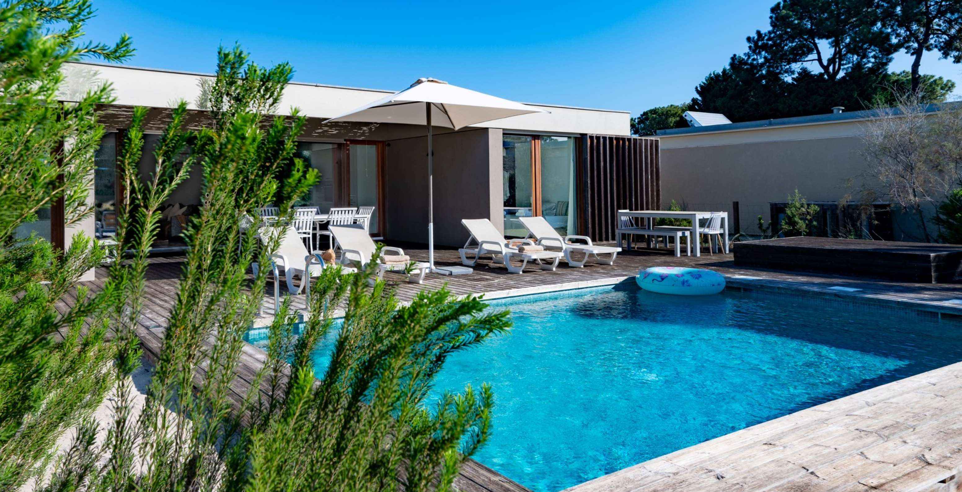 Les villas de 4 chambres du Pestana Tróia Eco Resort ont plusieurs chaises longues, un parasol et une bouée