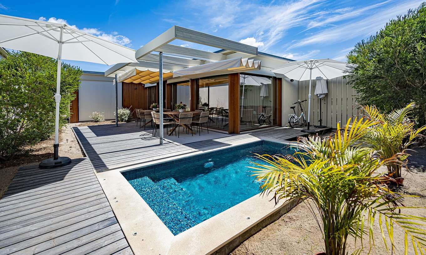 L'Aqua Villa du Pestana Tróia Eco Resort a une piscine privée avec table et chaises à côté