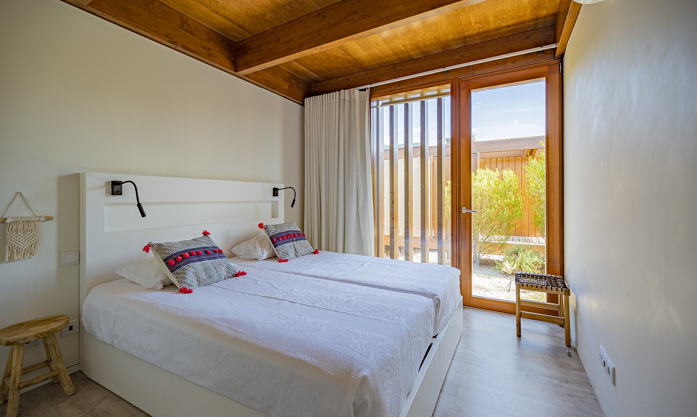 La Tree Villa avec piscine privée du Pestana Tróia Eco Resort a un lit double et une fenêtre du sol au plafond