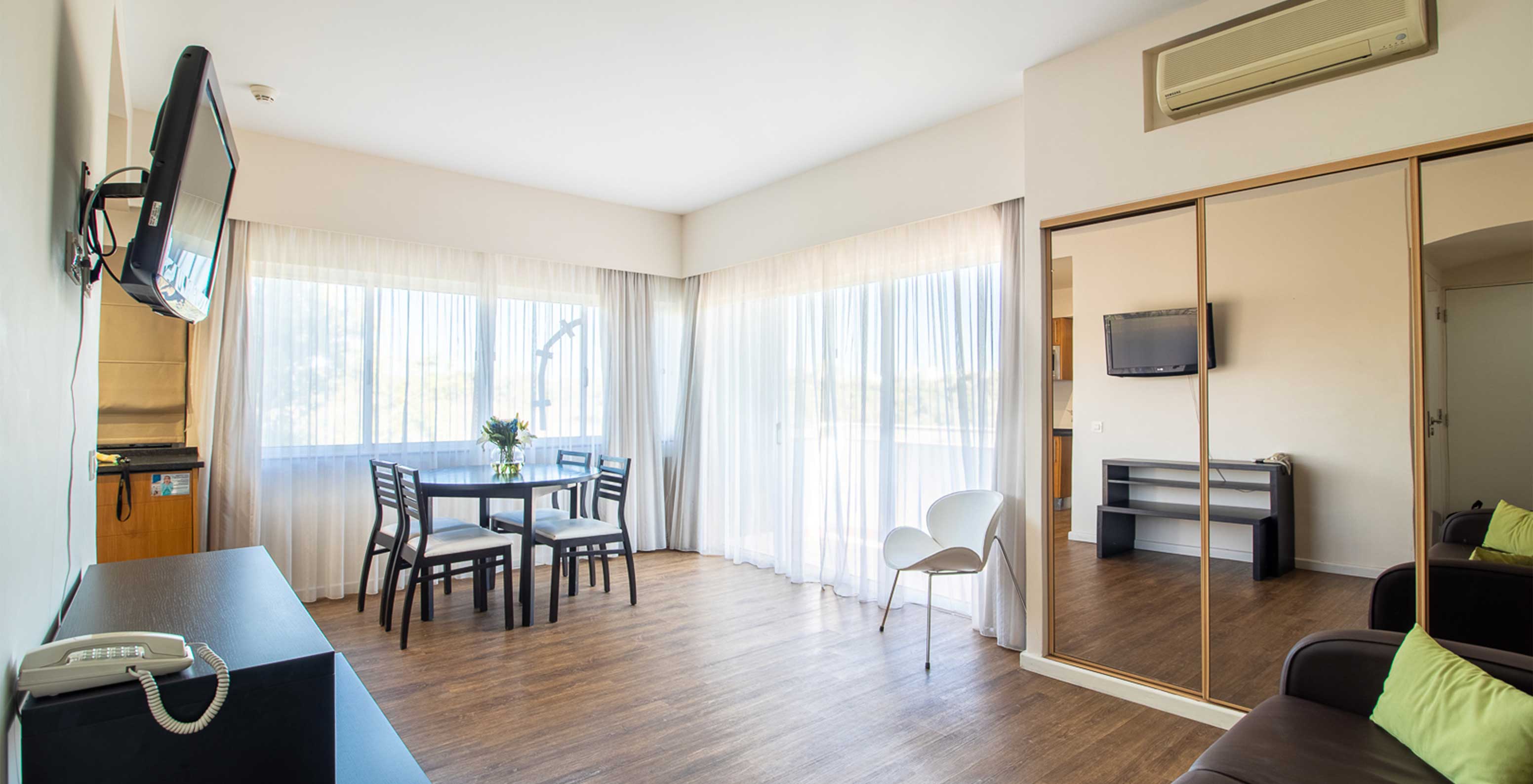 L'Appartement T1 Vue Jardin du Pestana Alvor Atlântico a un canapé avec télévision et un placard avec miroir