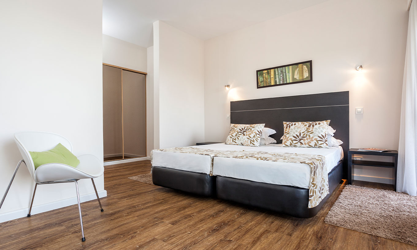 L'Appartement T1 Vue Mer du Pestana Alvor Atlântico a un lit double, une chaise et un placard