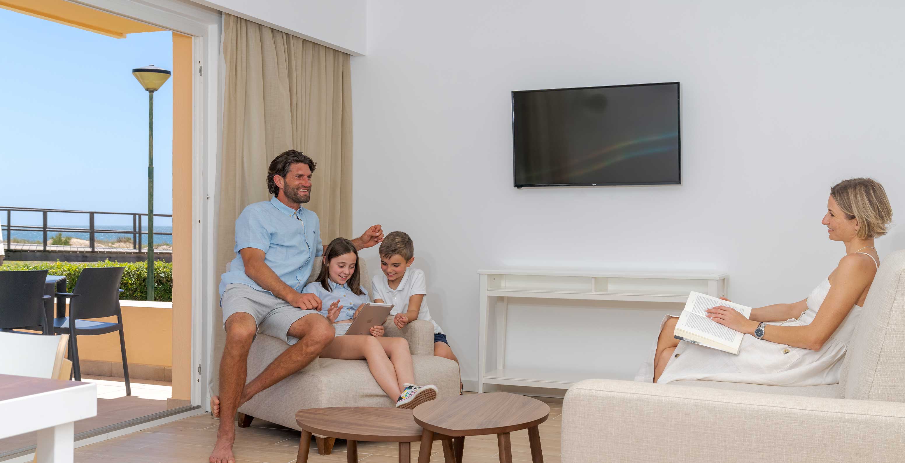 Famille profitant de moments de qualité sur les canapés du Pestana Alvor Beach Villas