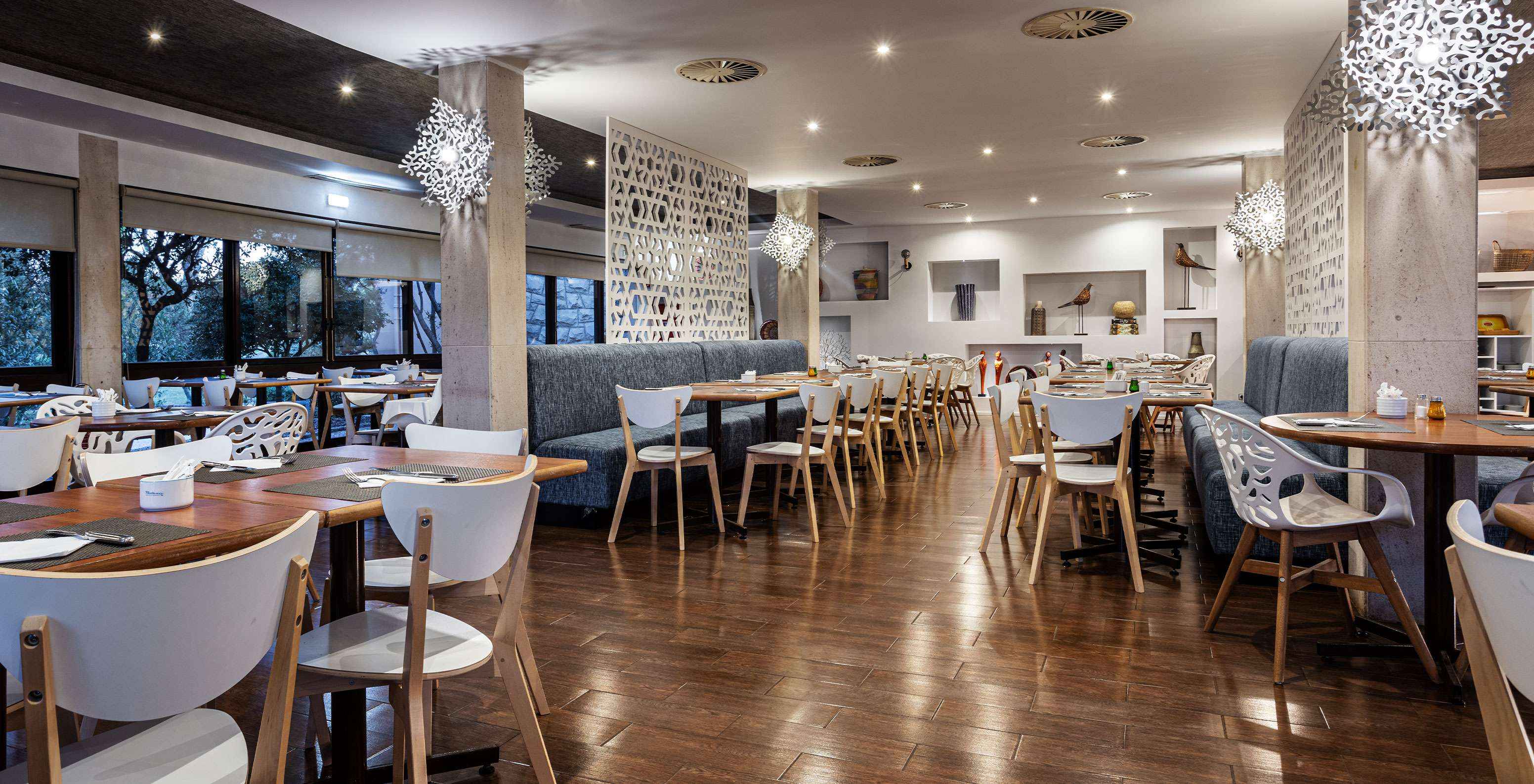 Restaurant spacieux avec plusieurs tables, chaises et canapés pour profiter d'un repas