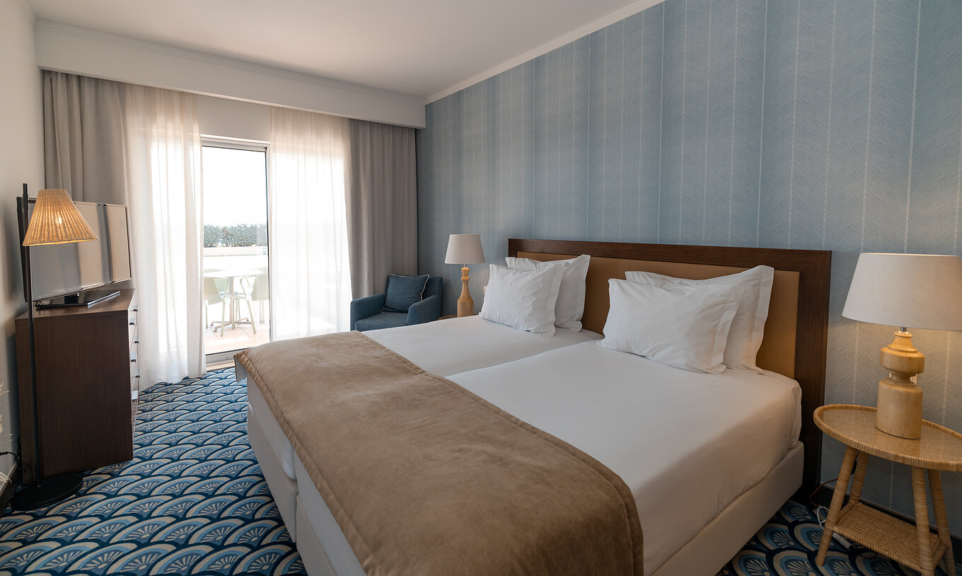 Appartement T1 Vue Jardin au Pestana Alvor Beach Villas dispose d'une chambre avec deux lits et fenêtre sur le balcon