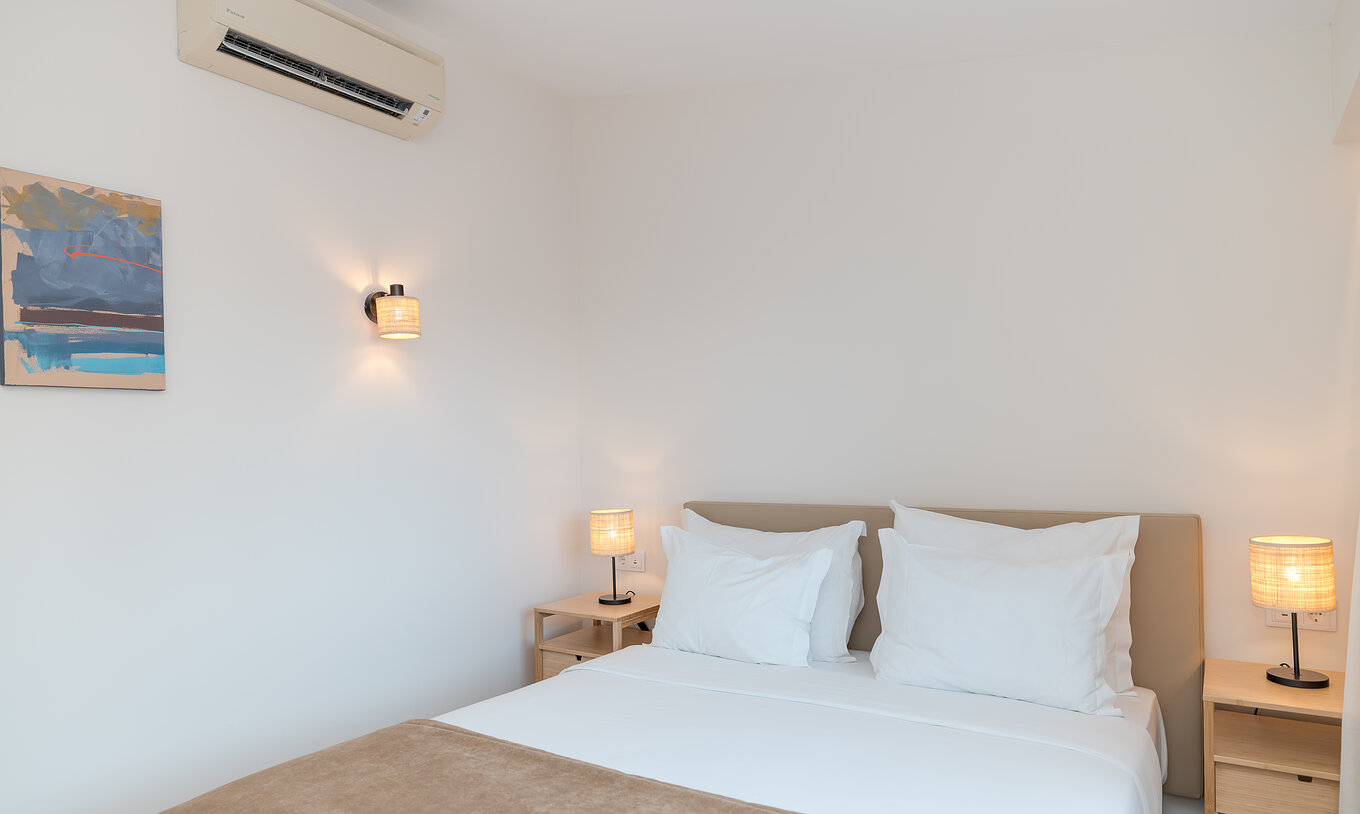 Villa 2 Chambres Vue Jardin au Pestana Alvor Beach Villas dispose d'une chambre avec lit double, tableau et climatisation