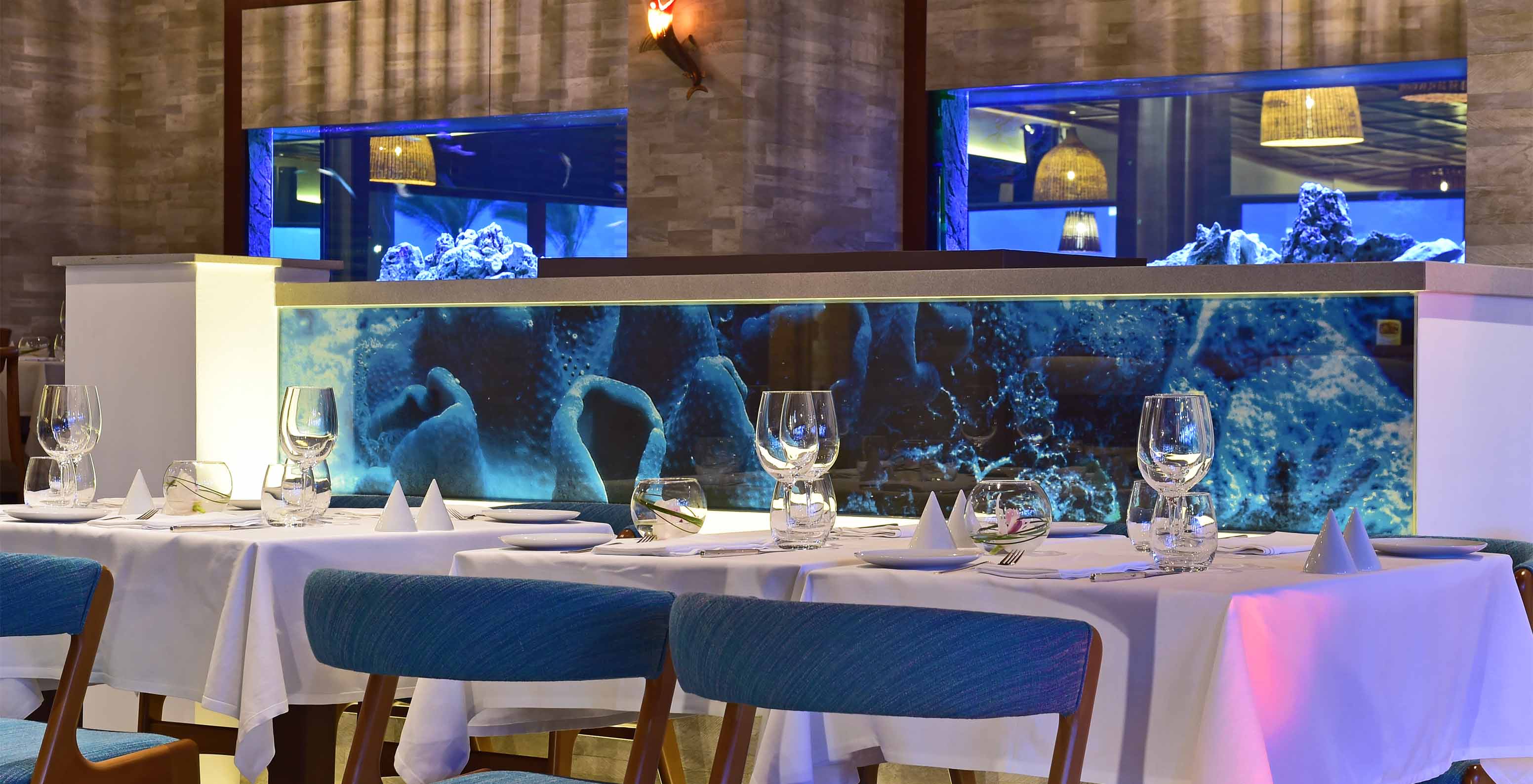 Le restaurant Sul, à l'Hôtel 5 étoiles en Algarve, a des aquariums entre les zones et des chaises rembourrées