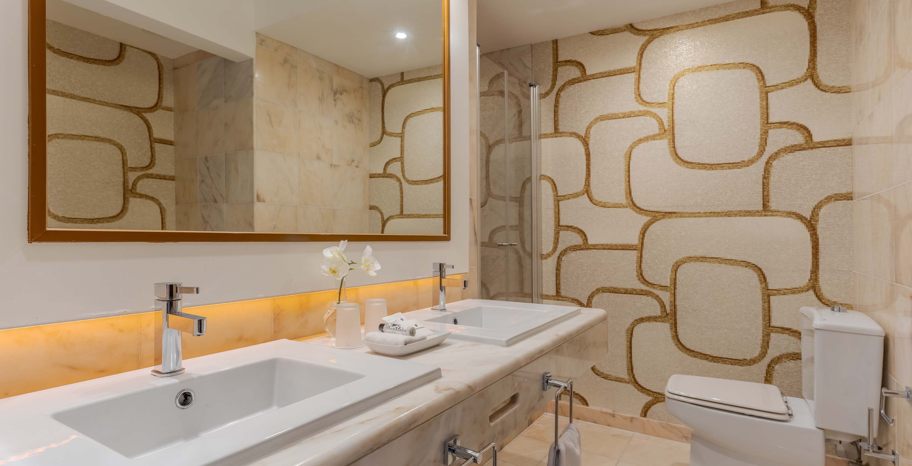 Le Deluxe Vue Mer du Pestana Alvor Praia a salle de bain en marbre avec deux lavabos, grand miroir et WC