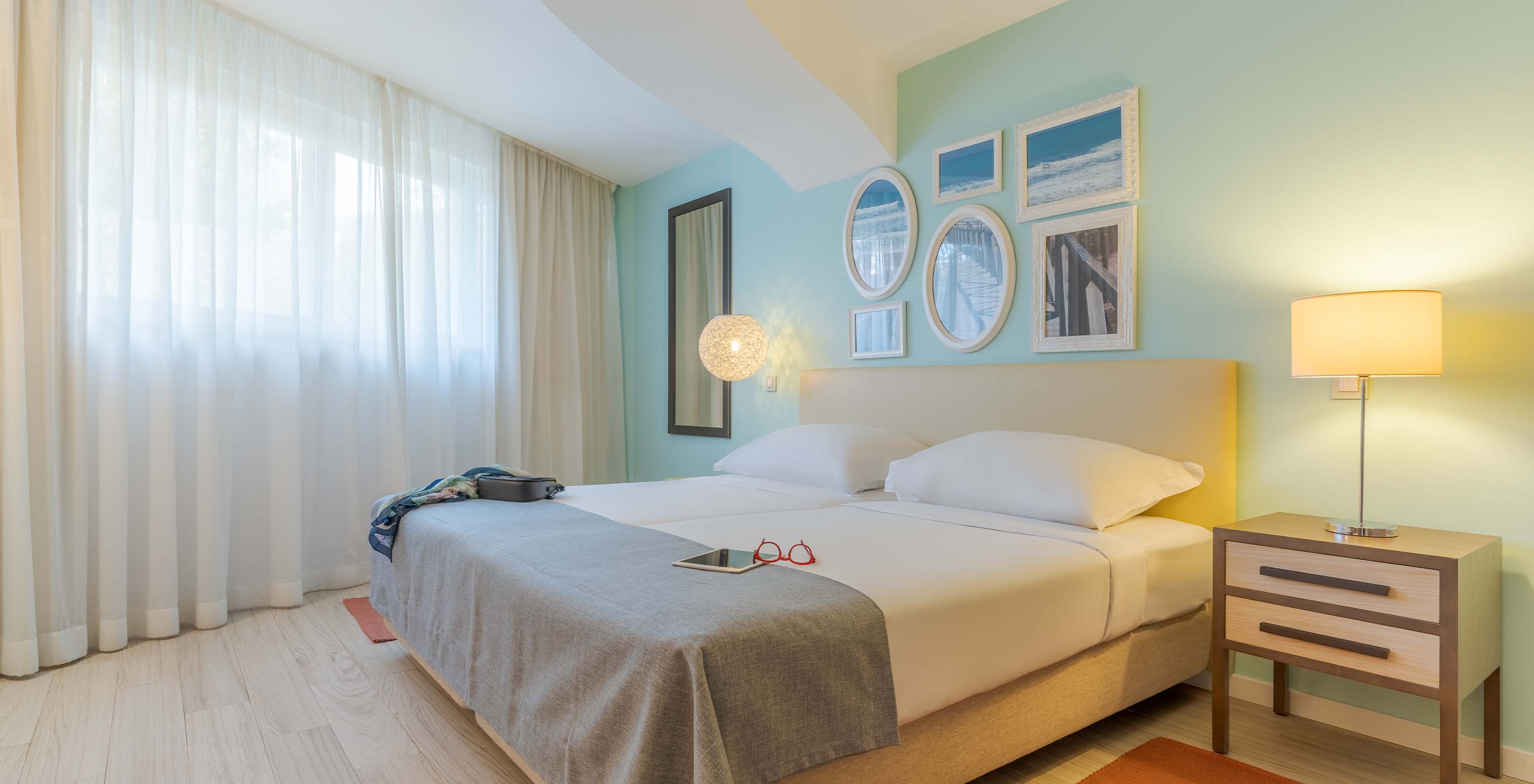 La Suite T1 Vue Jardin du Pestana Alvor Praia a deux lits unis, table de nuit avec lampe, tapis et tableaux