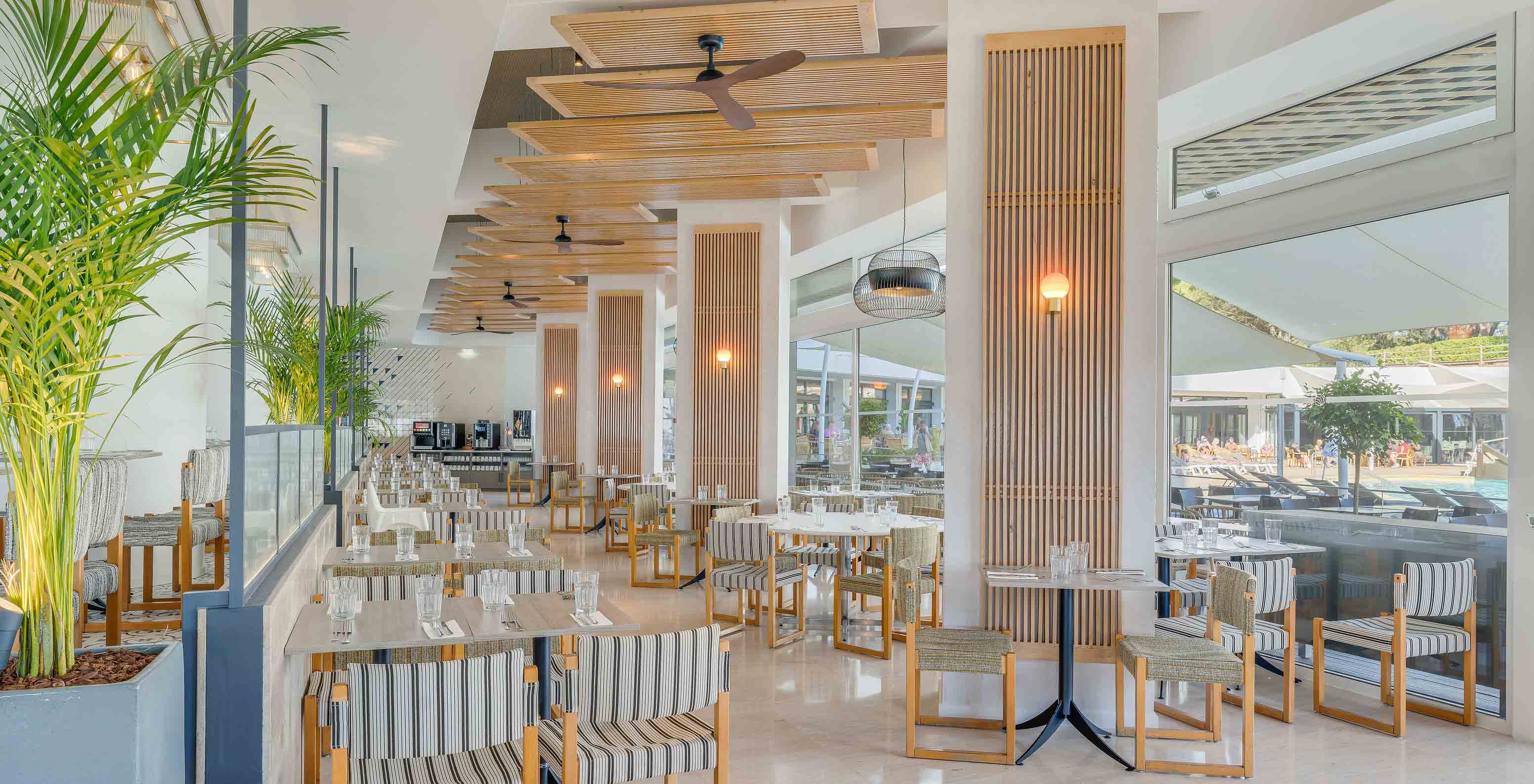 Le bar Acqua, de l’hôtel tout compris en Algarve, dispose de tables et de chaises avec beaucoup de lumière naturelle.